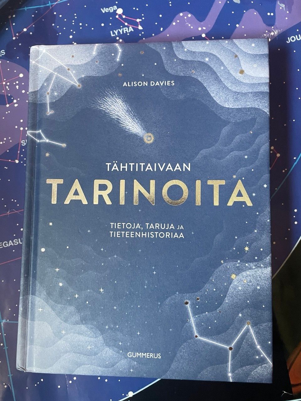 Tähtitaivaan tarinoita. Utuisen sininen kansi jossa tähtikuvioita ja lentävä komeetta.