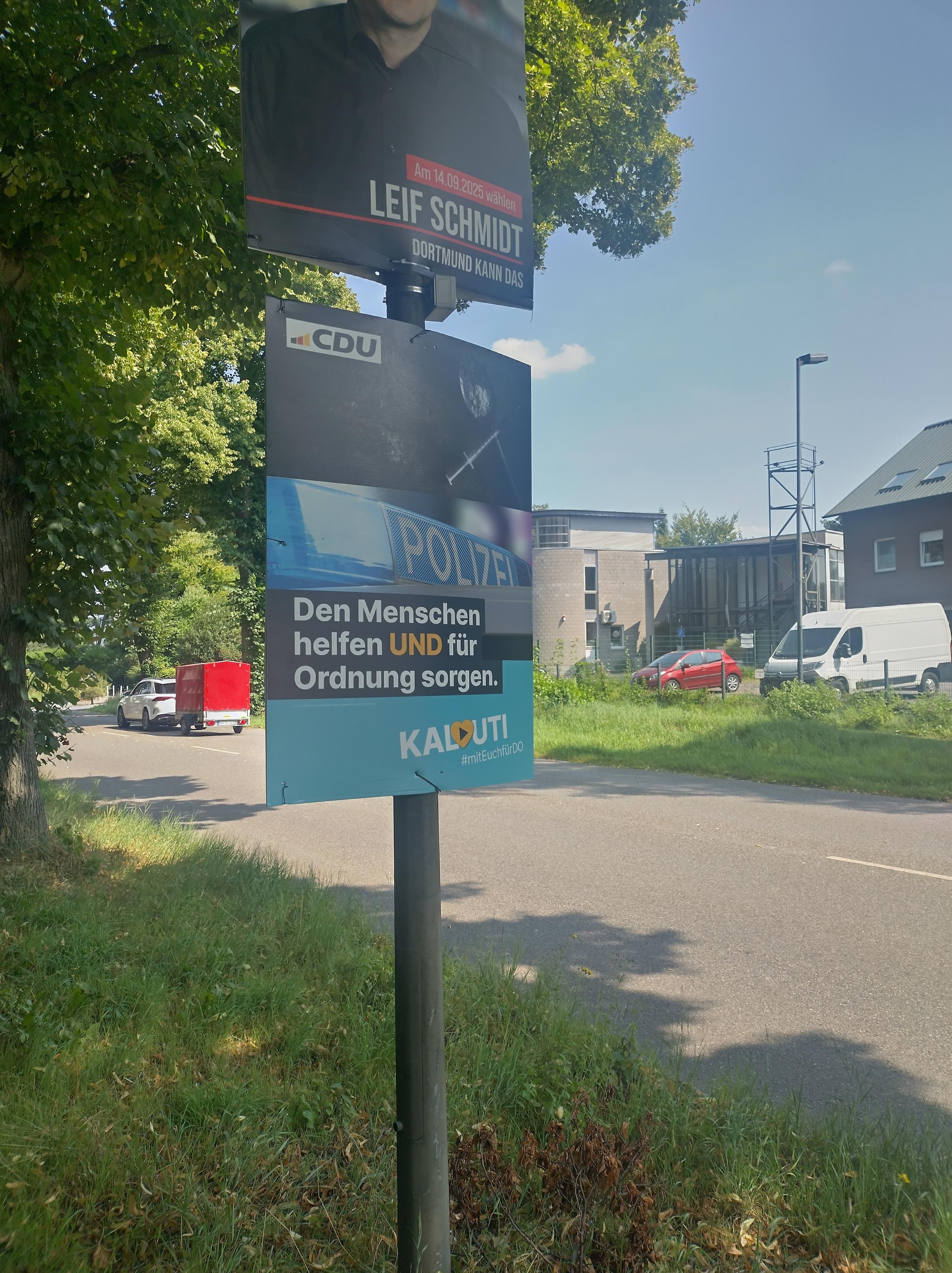 Wahlplakat "Den Menschen helfen UND für Ordnung sorgen" ein Polizei-Schriftzug und dunkles Fixer-Besteck