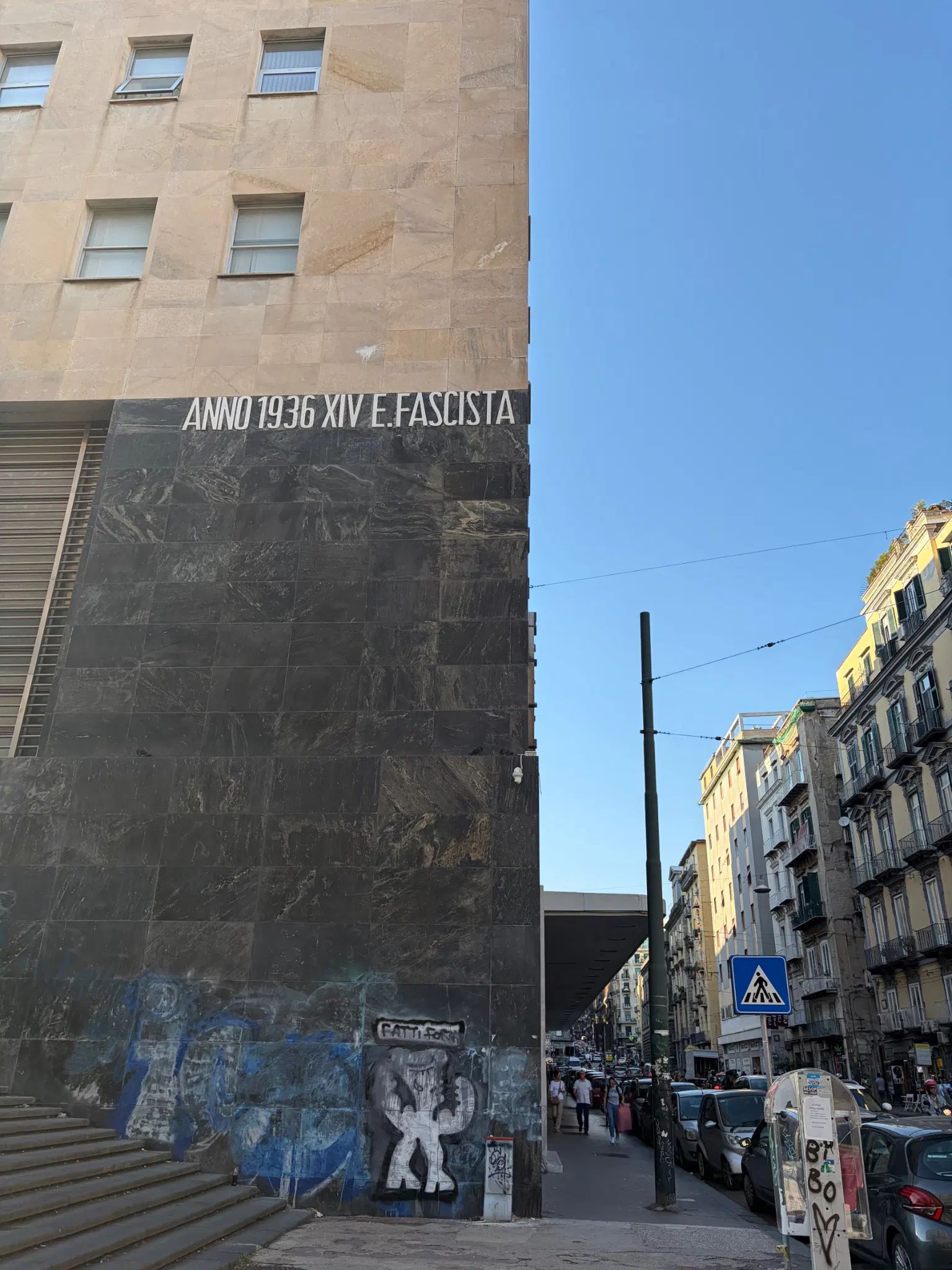 Foto del muro della via laterale delle poste, con scritto "ANNO 1936 XIV E.FASCISTA"