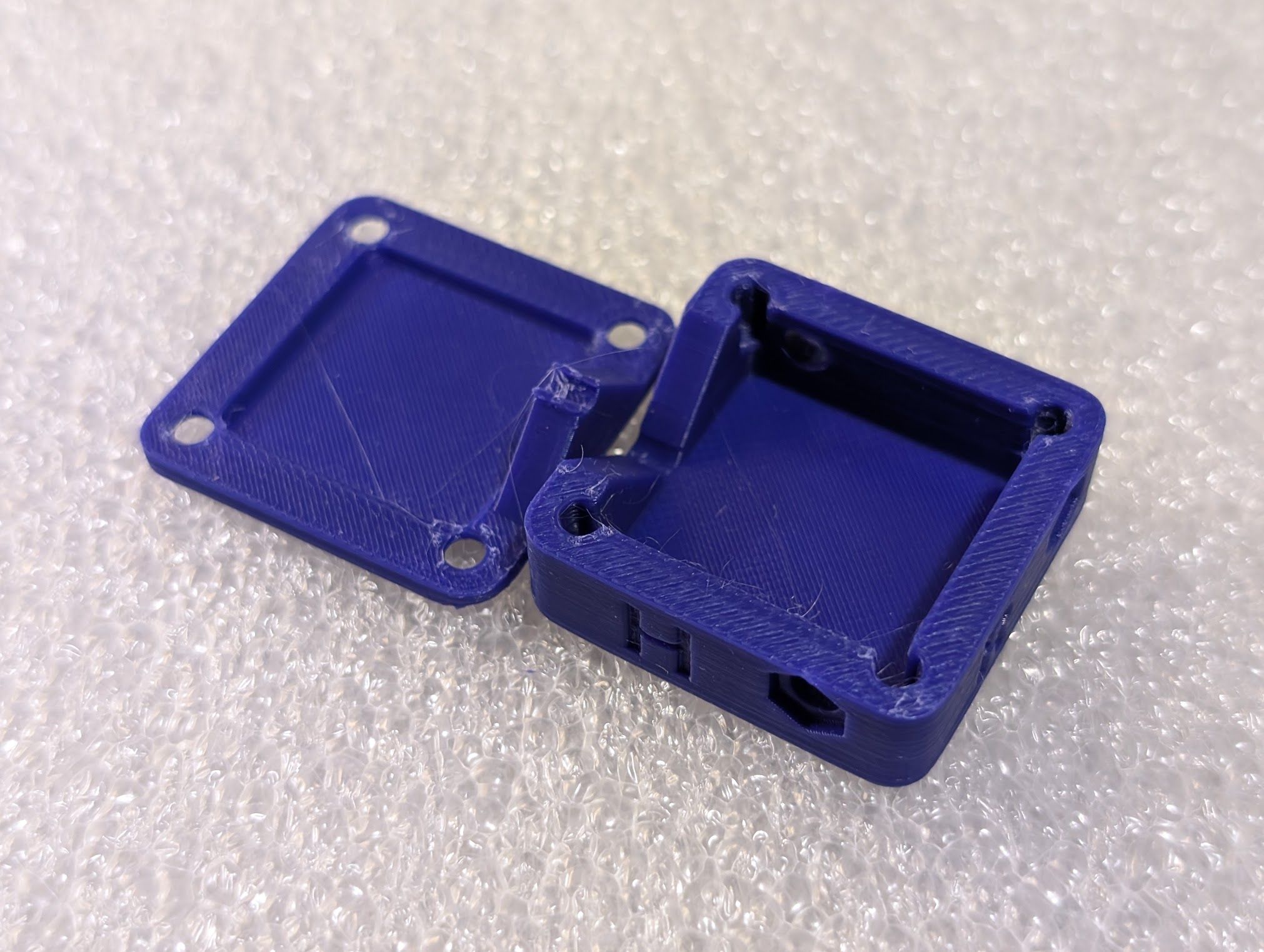 New 3d-printed box design showing redesigned coax capture, with a 90° cut-out in the side of the box and a matching tab in the lid.