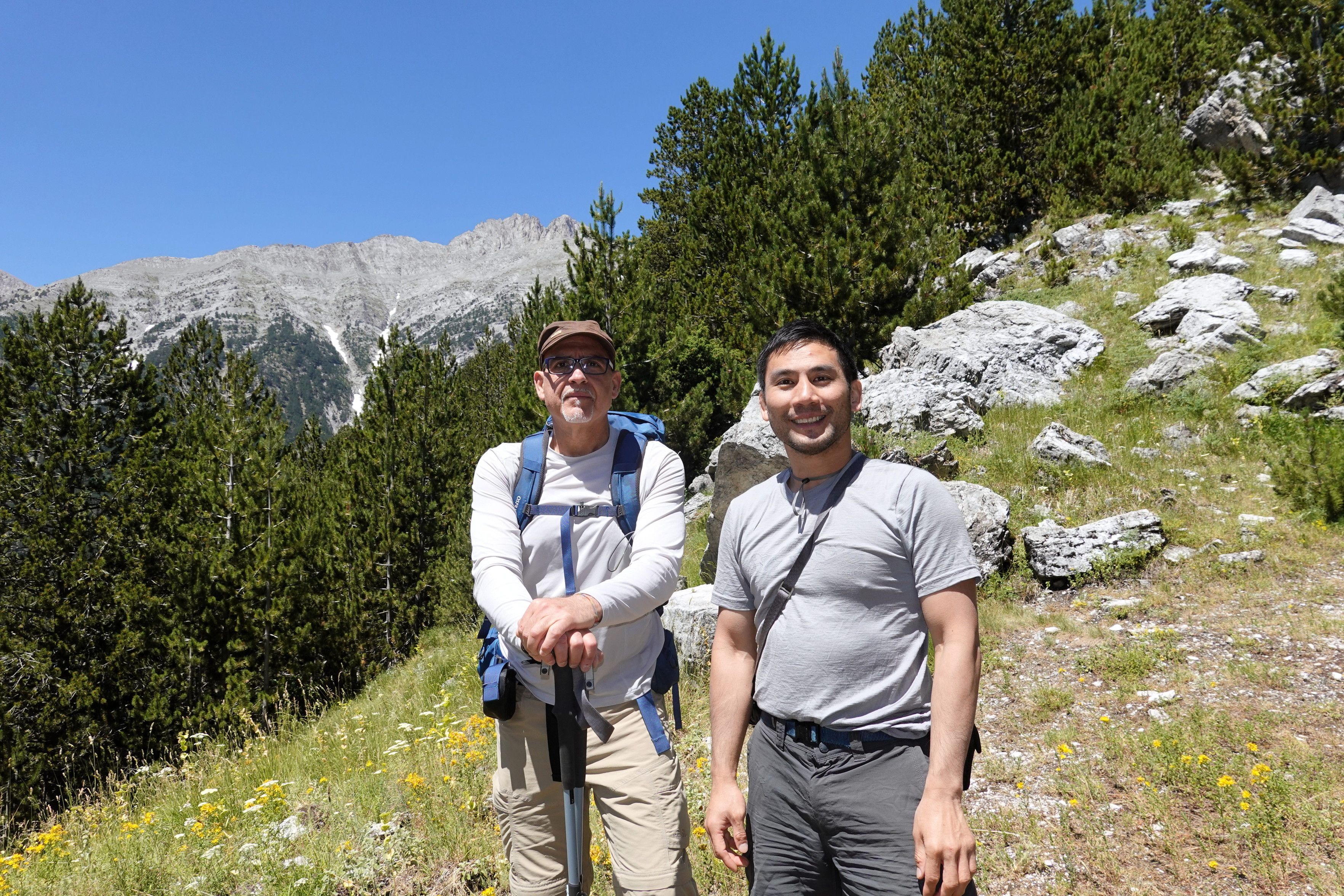 My colleague Mario and me standing in a field, with trees behind.