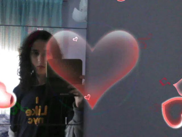 Foto di me ancora col pigiama allo specchio col mio new 3DS XL, effetto festa con vari cuori sullo schermo. Ho un'espressione in faccia tra il vuoto e il boh