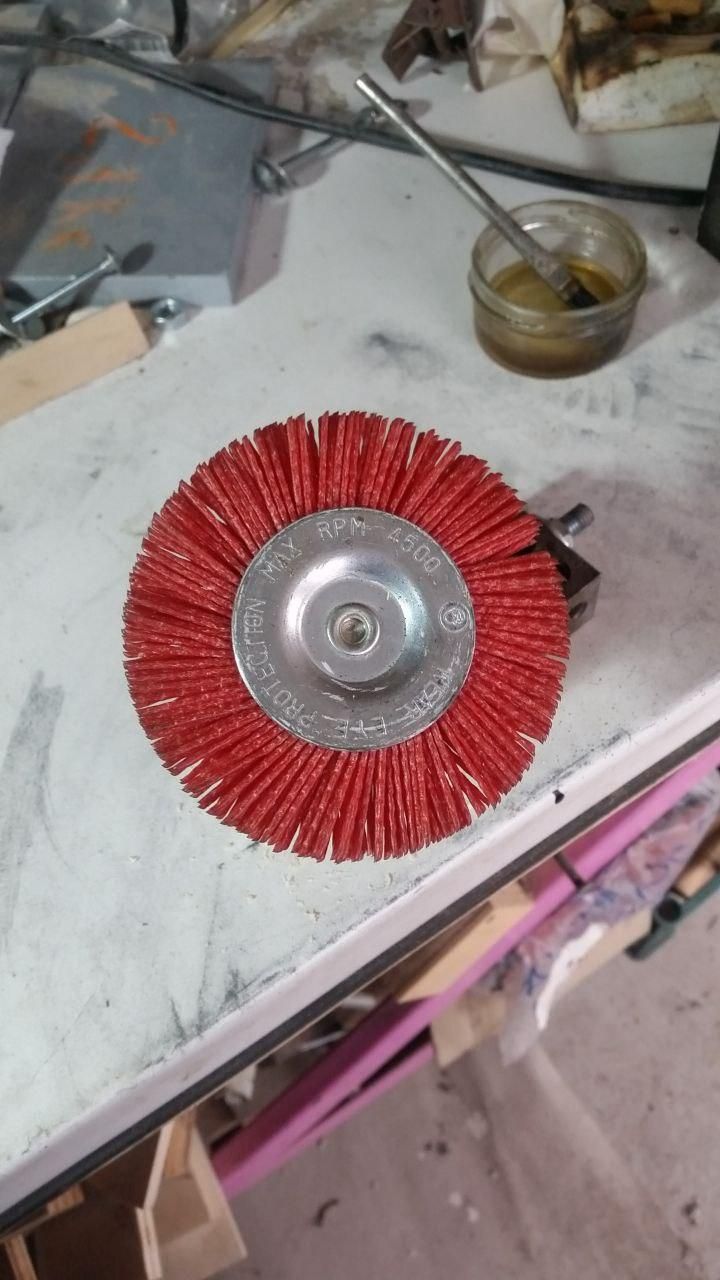 Spazzola tonda in nailon (forse), color rosso aranciato.