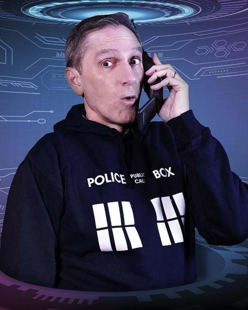 Foto standard di Paolo con felpa TARDIS di Doctor Who e telefonino analogico d'epoca in mano, espressione sorpresa o rincitrullita, fate voi