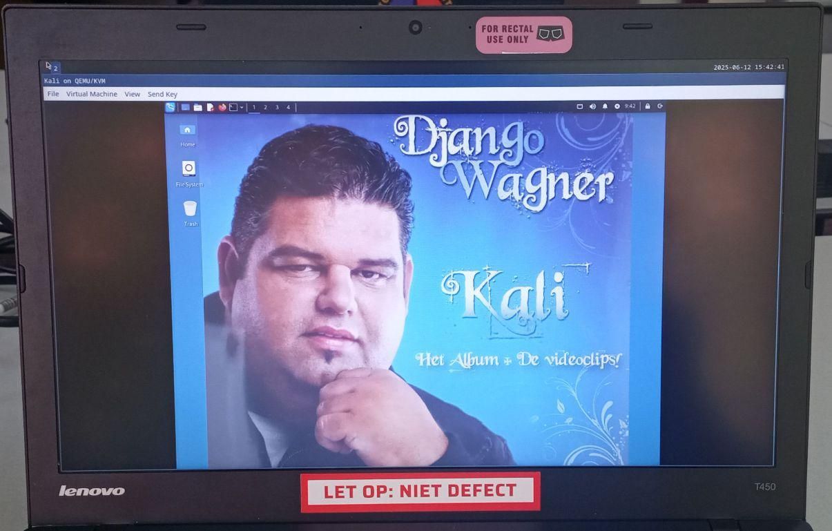 A Thinkpad with Linux setup. On the laptop are stickers indicating that the machine isn't broken and only for rectal use. On the screen is a Kali Linux VM running, with as background the album cover of Django Wagner's (a Dutch schlager singer) Kali. The whole setup exhudes class and elegance.