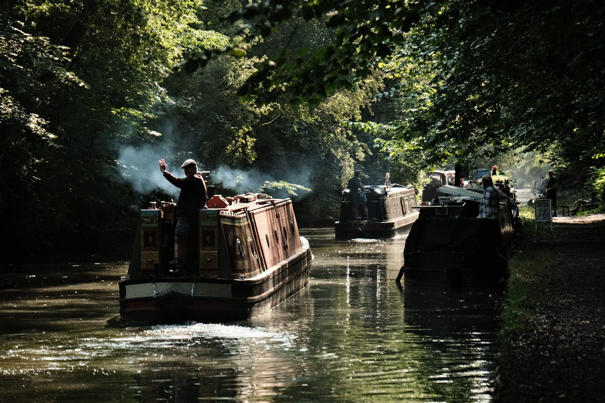 2 narrowboats leaving their moorings in the early morning.