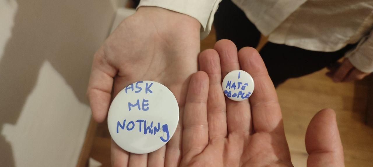due spillette con scritto "ask me nothing" e "I hate people" rispettivamente