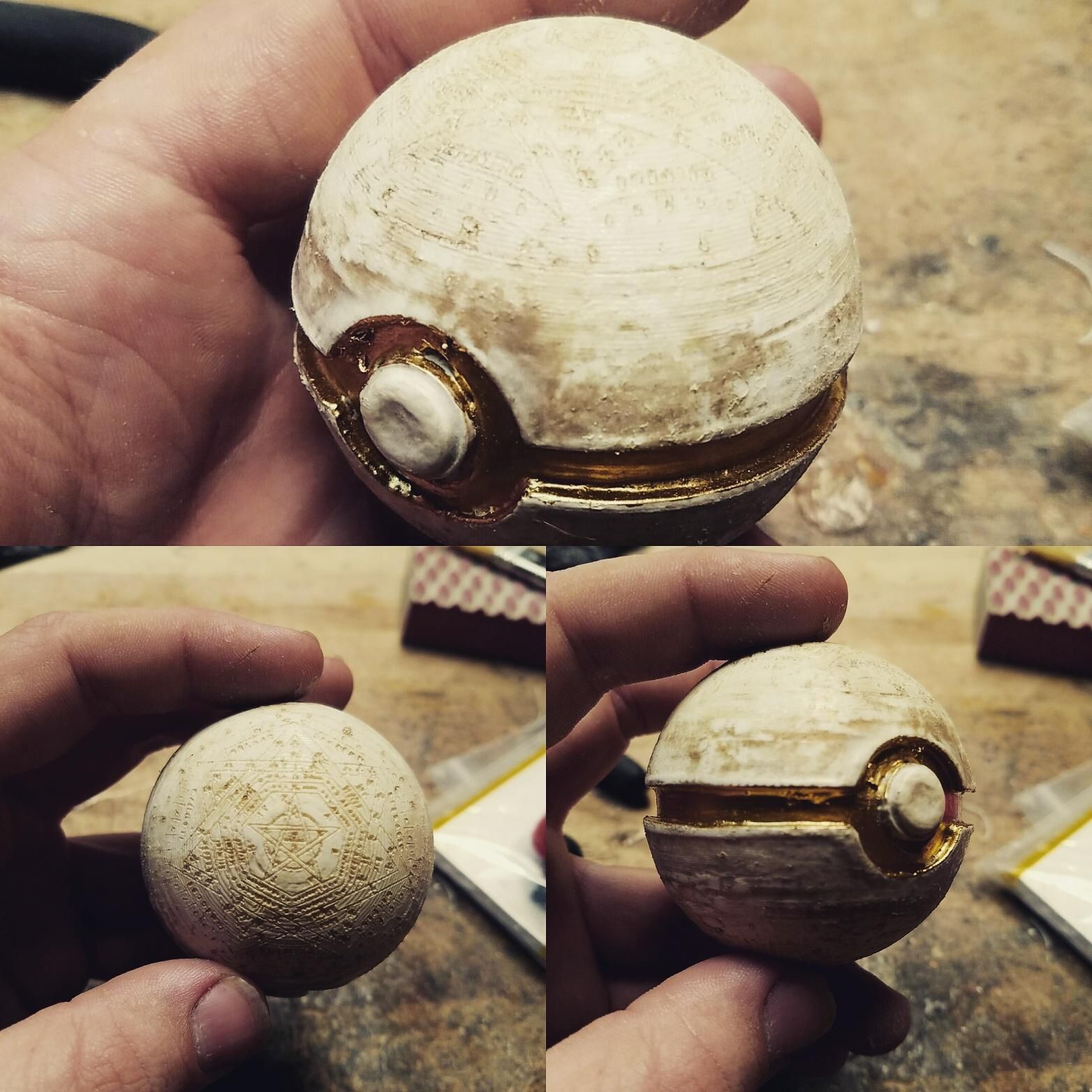 A small bone-white pokeball with gold inlay and John Dee's Sigilum Dei engraved in the top