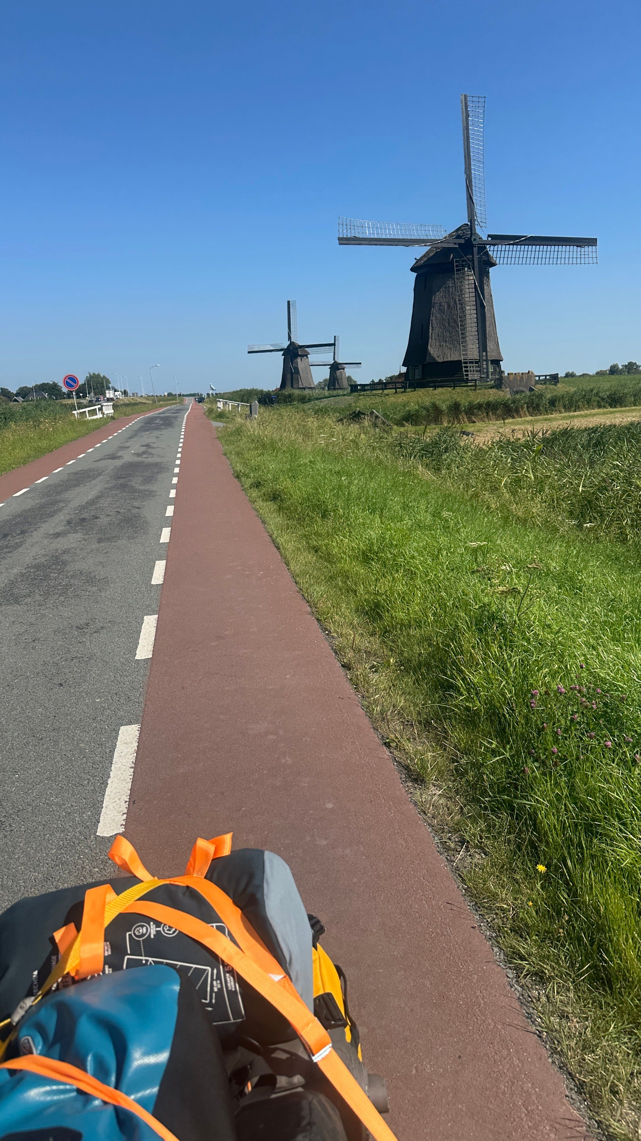 Bike path next to three old windmills 