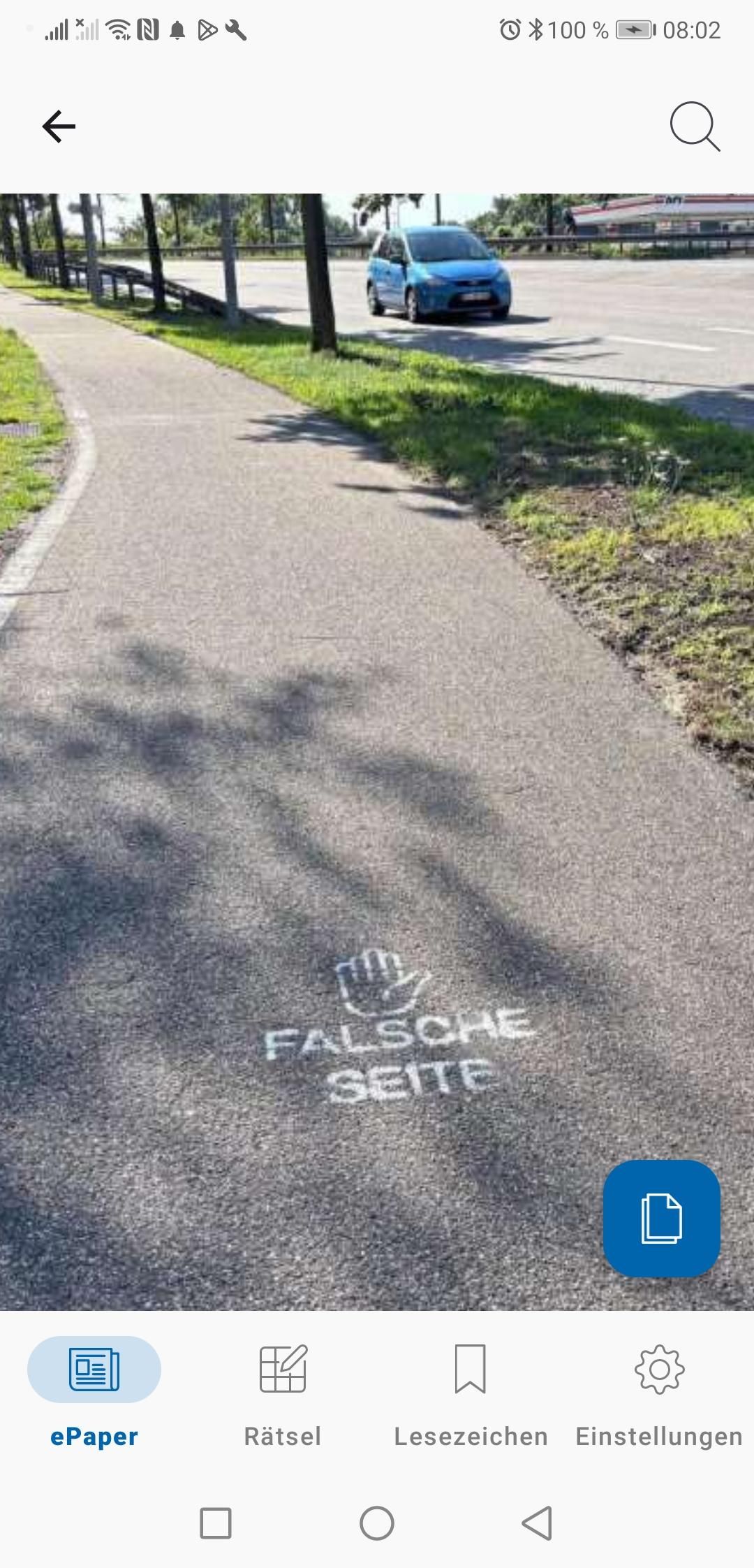 Das Foto zu der Zeitungsmeldung zeigt ein Stück Asphaltweg mit dem aufgetragenen Logo