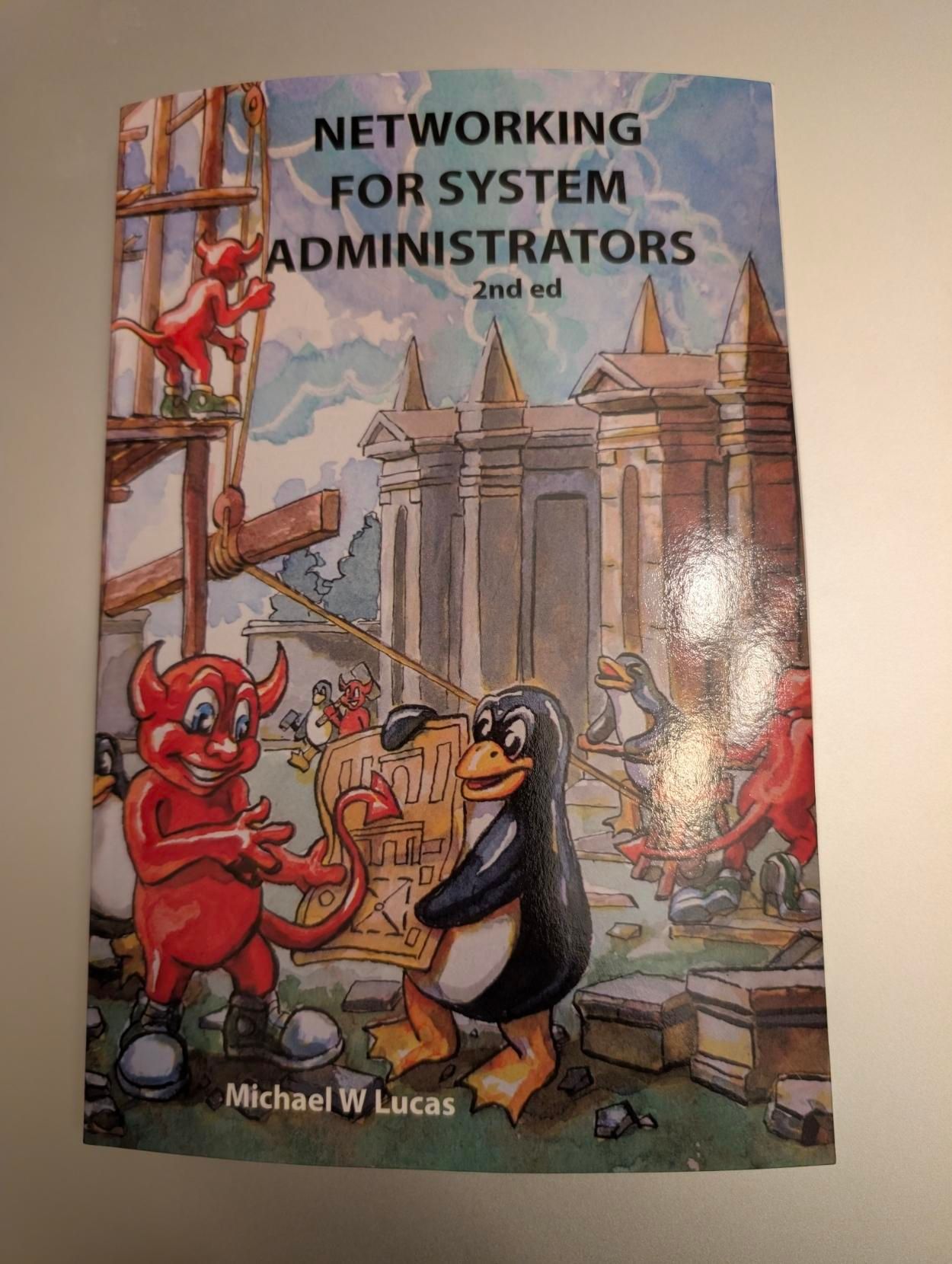 Book cover titled "Networking for System Administrators, 2nd ed" by Michael W. Lucas. The illustrated cover shows cartoon-style mascots