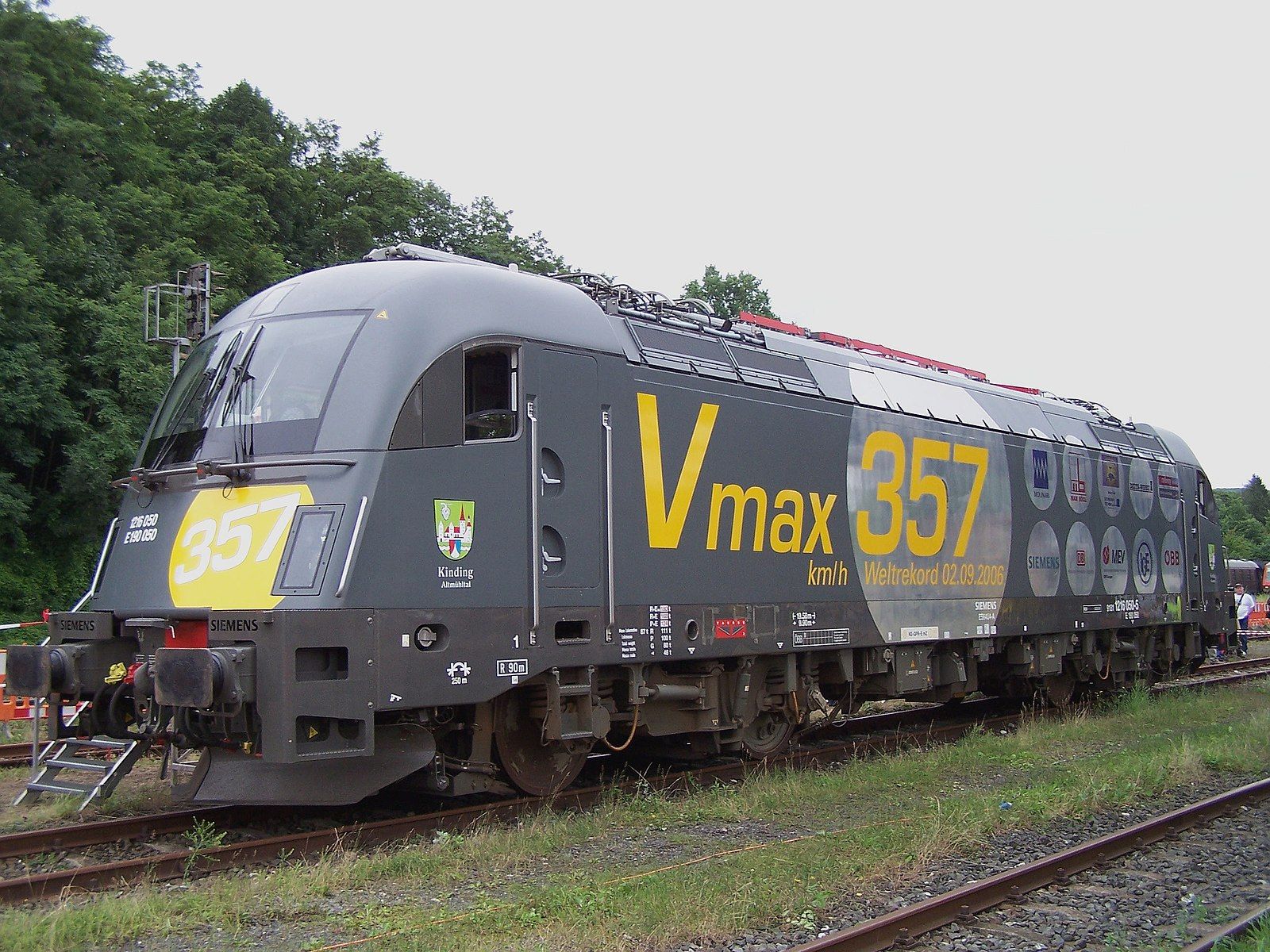 A modern electric locomotive with the label "Vmax 357"