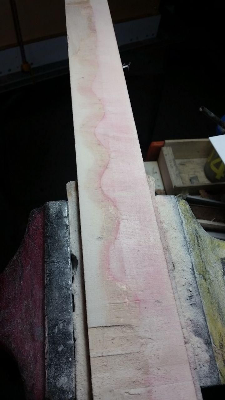 Un pezzo di compensato sul quale è stato usato alcool denaturato per sciogliere la colla vinilica.
L'alcool ha lasciato giù il colore e un lato del compensato è rosa.