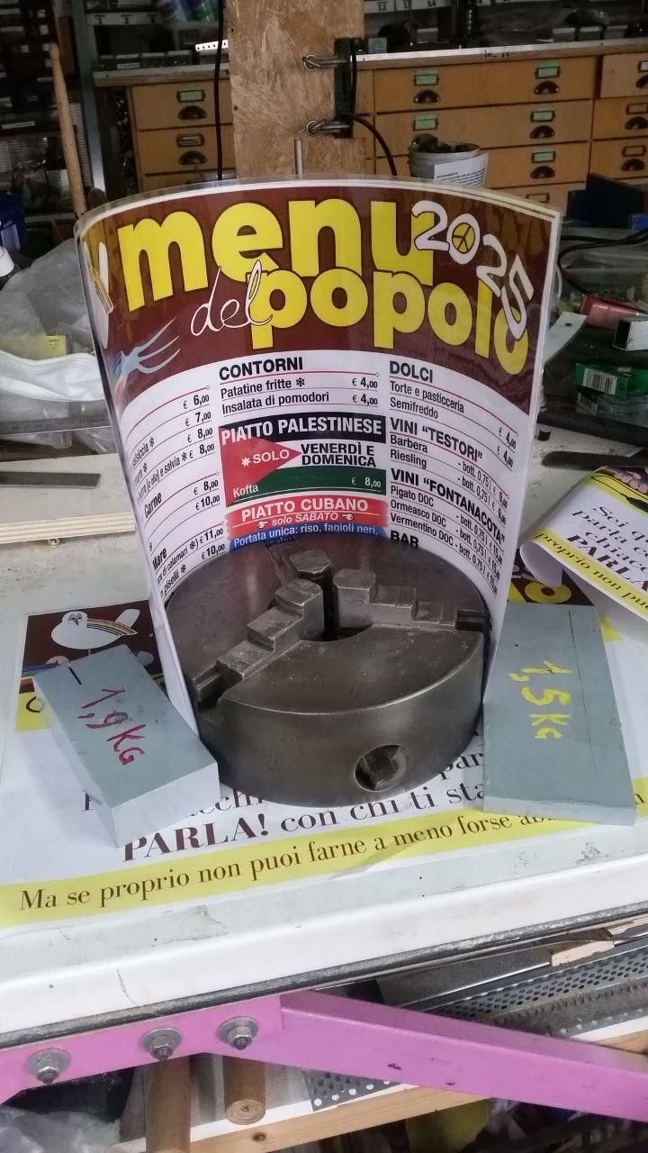 Mandrino a tre ganasce da 200 mm con un menu plastificato formato A3 parzialmente arrotolato intorno.
Lascio a chi legge il divertimento di calcolare l'angolo al centro coperto dal menu (hint: è leggermente superiore a 120°).