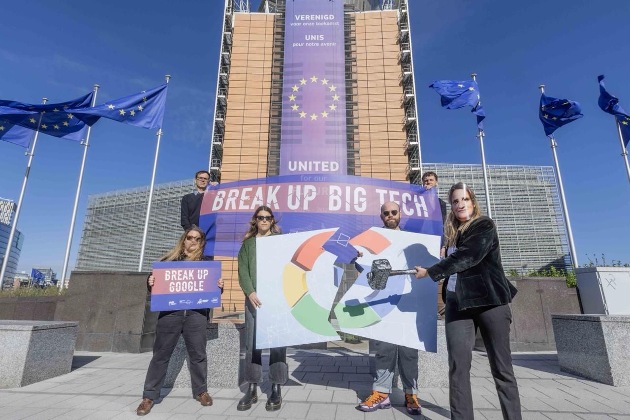 Activists standing outside the EU Commission building, mimicking Commissioner Ribera breaking up Google's logo with a hammer. 