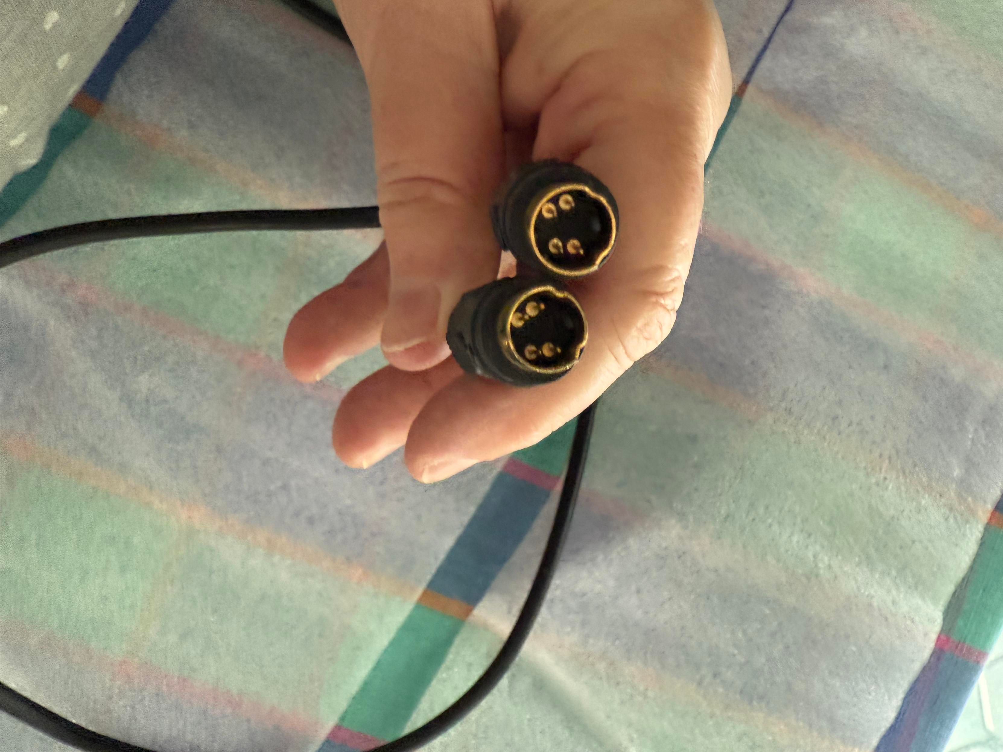 Hand holding both ends of a mystery cable