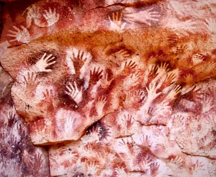 The cave of hands, in Santa Cruz, Argentina,a wall of dozens of handprints in various layers made at various ties. The colors of ante from white to red ti brown.some are placed on the naked rock, some spots have been painted white before the hand was placed and the pigment sprayed around it. It’s riotous and gorgeous. Hands of people who have been dead for seven thousand reaching out to us now.  