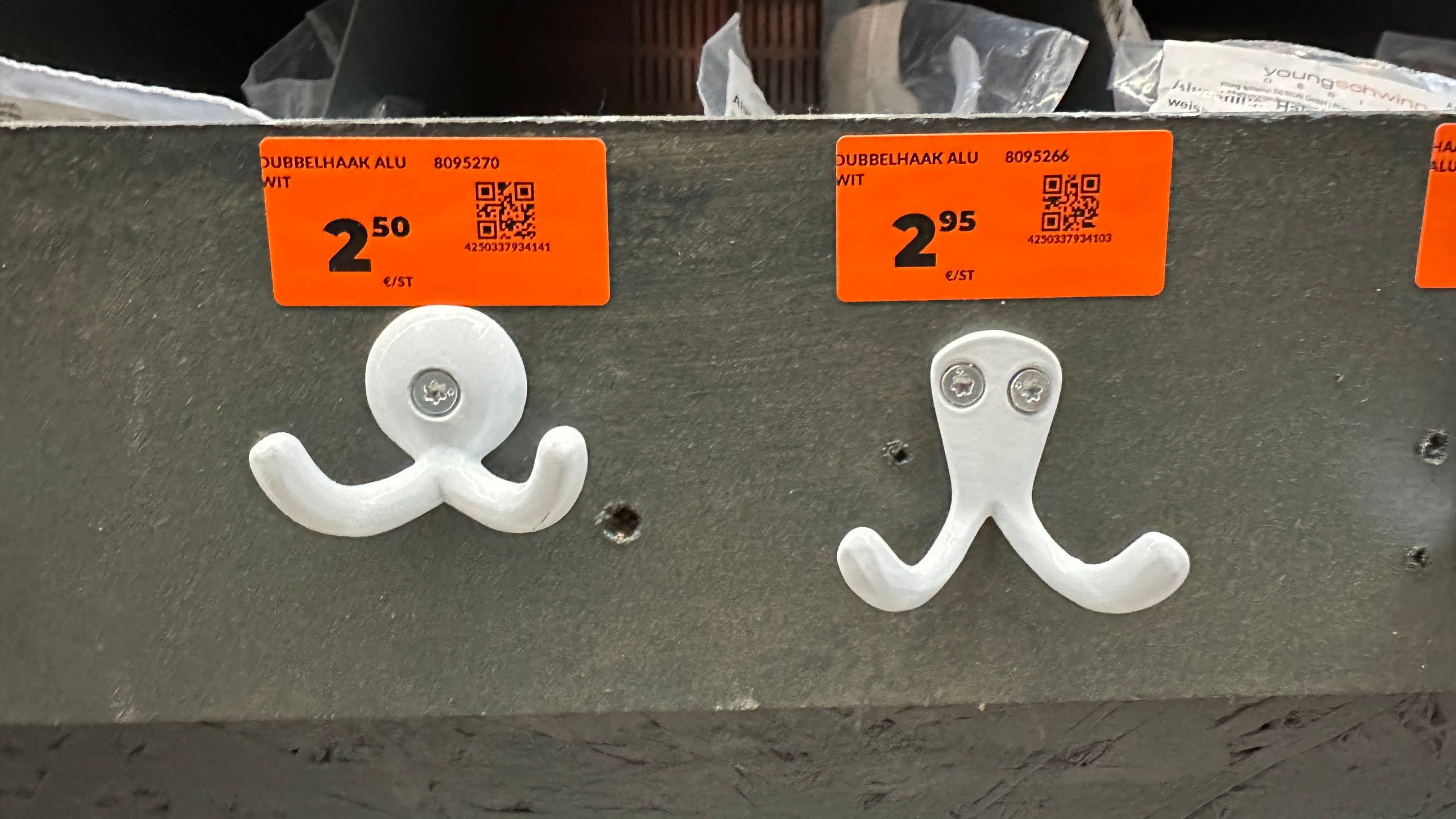 two coat hangers, one the classic "drunk octopus wants to fight you" with two unaligned screws and one cyclops with a single screw