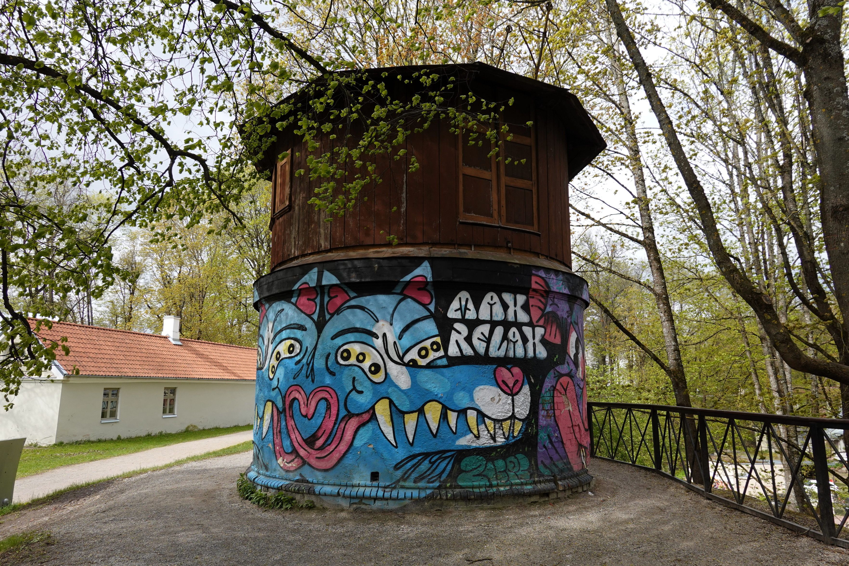 "MAX RELAX" says graffiti (blue wolf-like creatures) on a small wooden cylindrical tower.