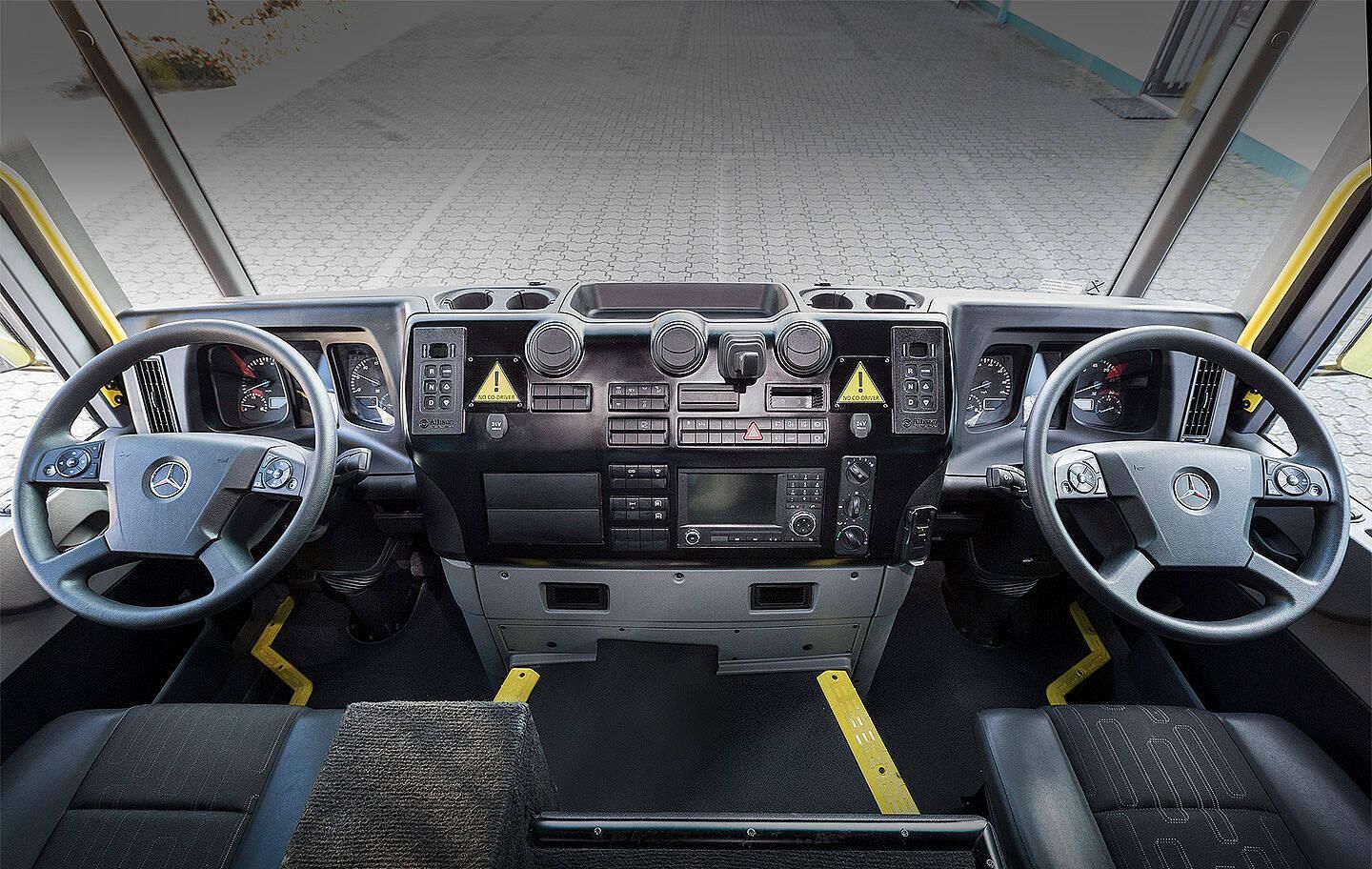 Camion della spazzatura Mercedes con doppio volante per evitare che l'operatore debba perdere tempo facendo il giro del camion.
