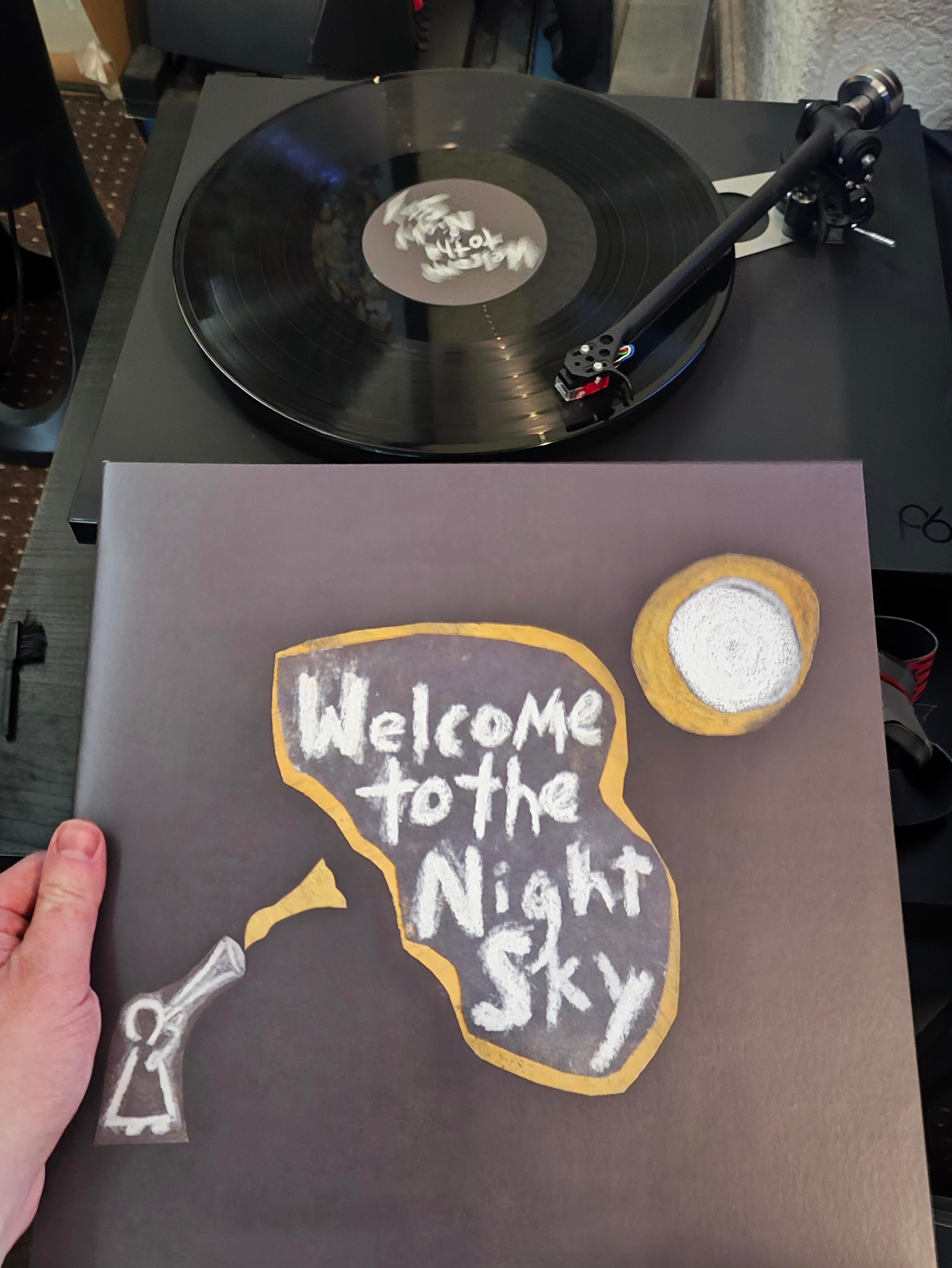 Basic drawn artwork of a moon and person holding something up with the title in a bubble in between 