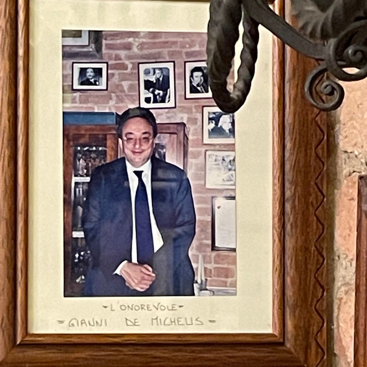a picture of gianni de michelis hanging on the wall of a restaurant