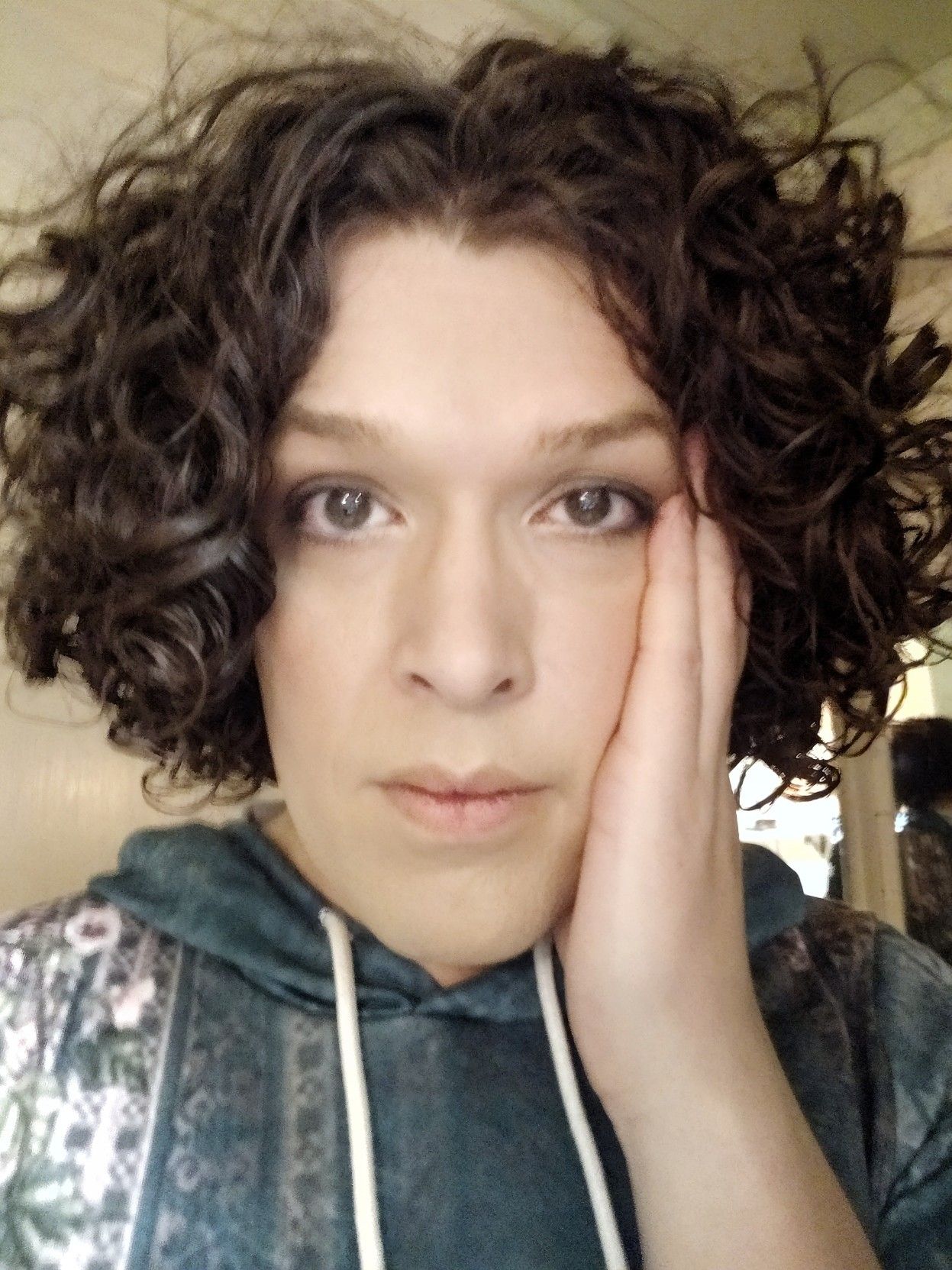 selfie, me with a bewildered expression holding my left hand to my cheek.