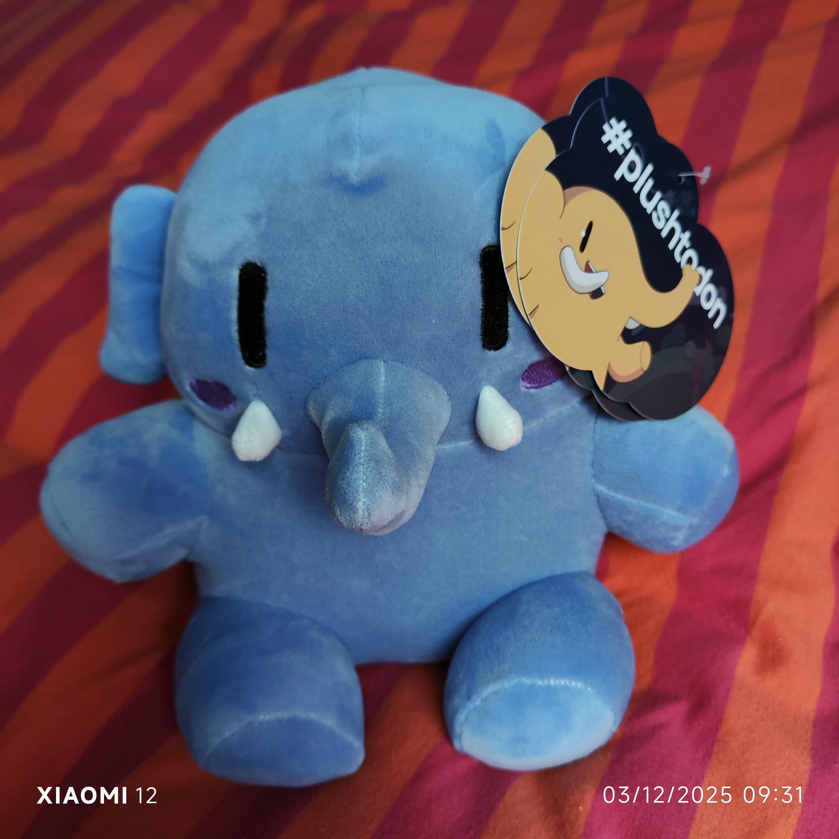A blue plushy elephant with a label saying plushtodon