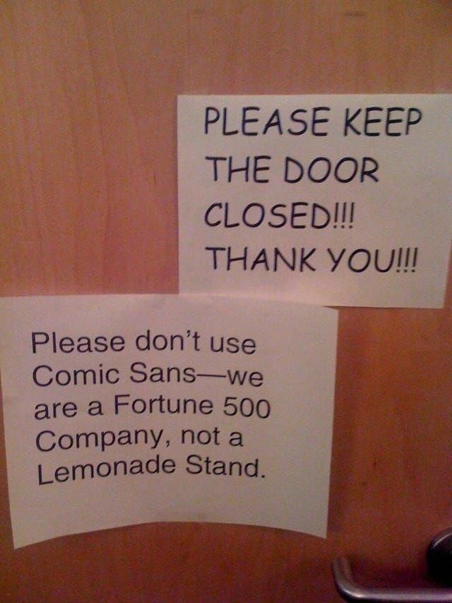 Porta con due cartelli.
Il primo, in Comic Sans, dice: "PLEASE KEEP THE DOOR CLOSED!!! THANK YOU!!!"
Il secondo, in Arial o qualcosa di simile, dice: "Please don'tuse Comic Sans — we are a Fortune 500 Company, not a Lemonade Stand".