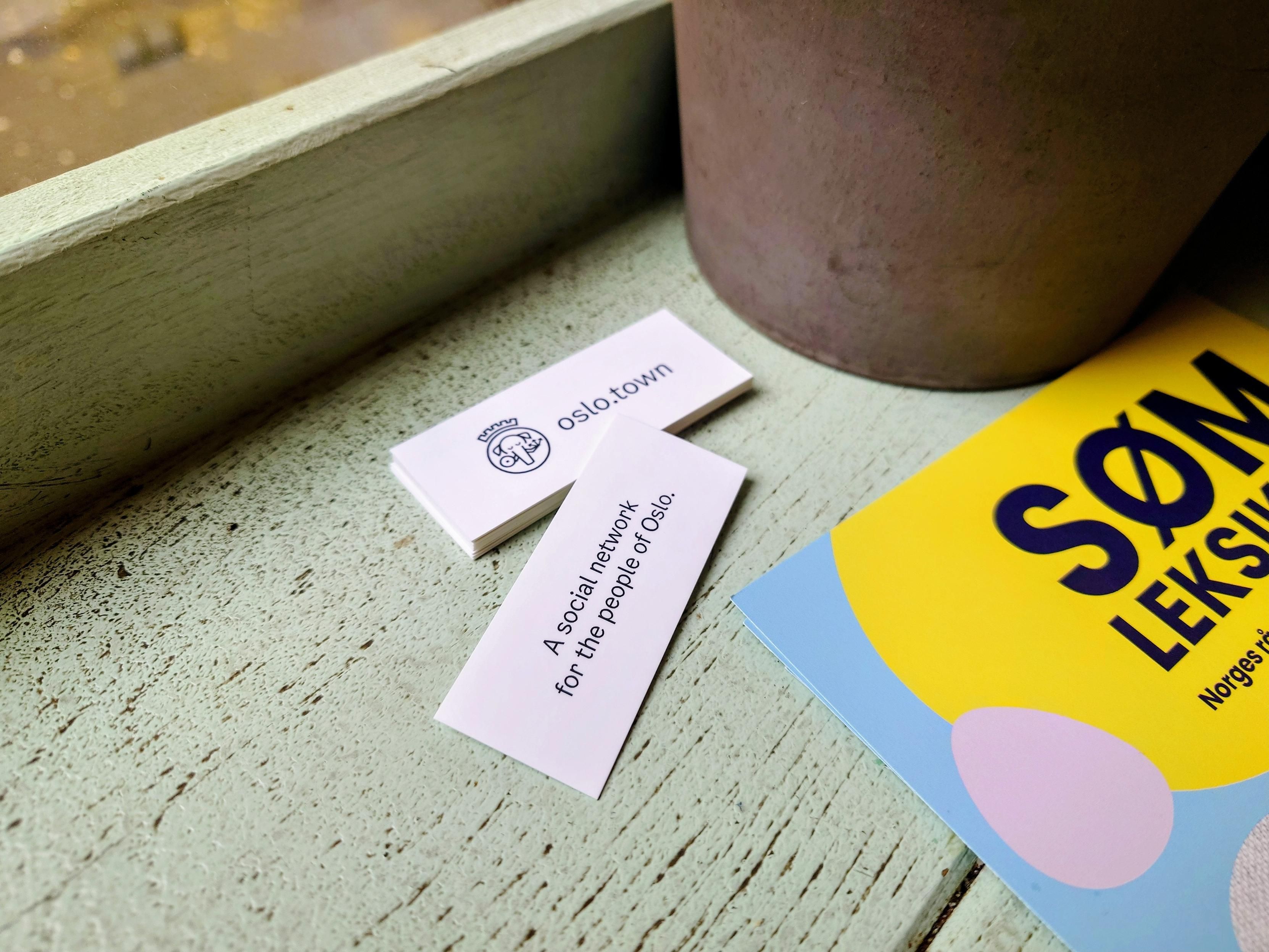 A photo of some mini moo cards in a local coffee shop advertising oslo.town Mastodon instance