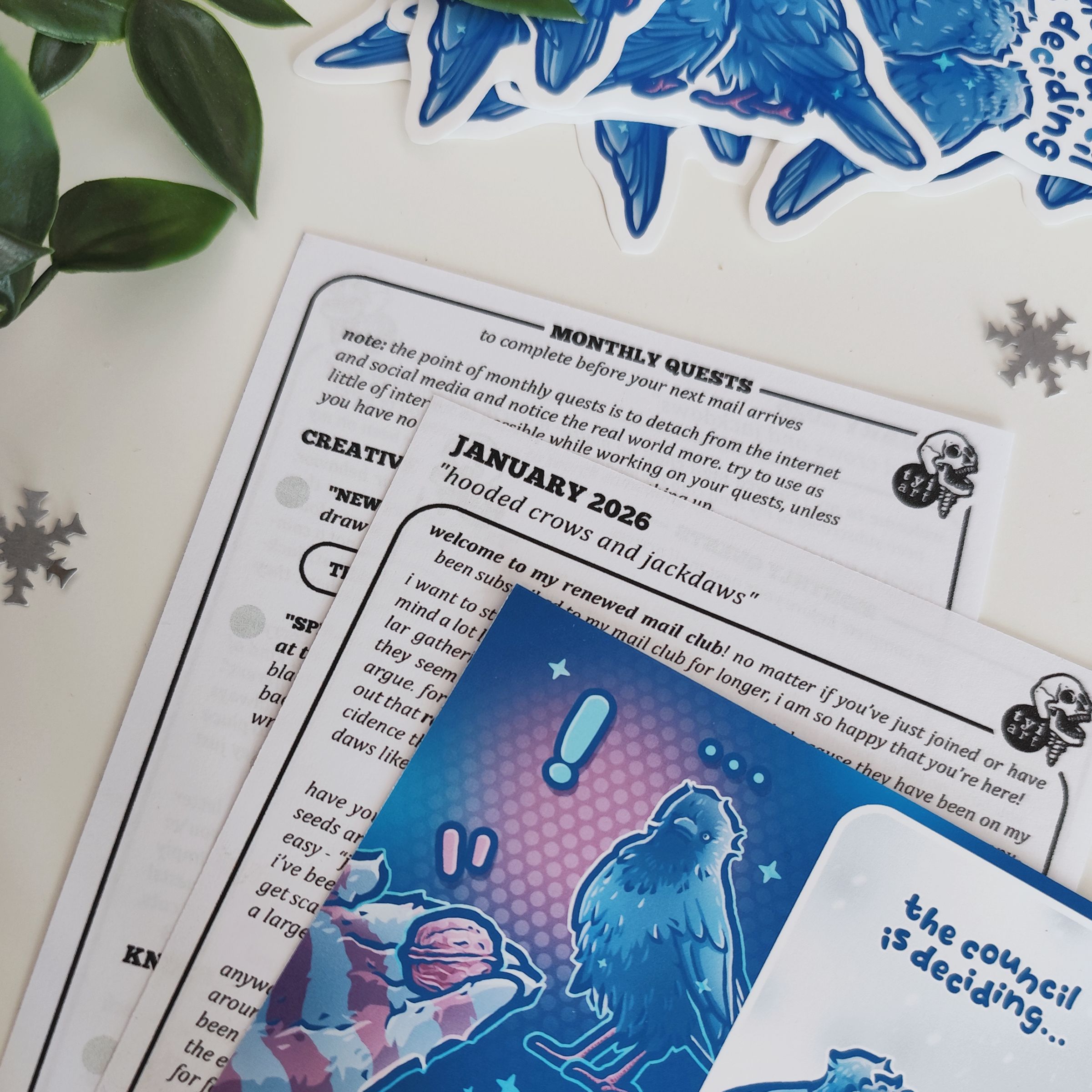 photo of my monthly mail club showing an art print with jackdaws, with a letter behind it that contains writing about theme inspiration and monthly quests