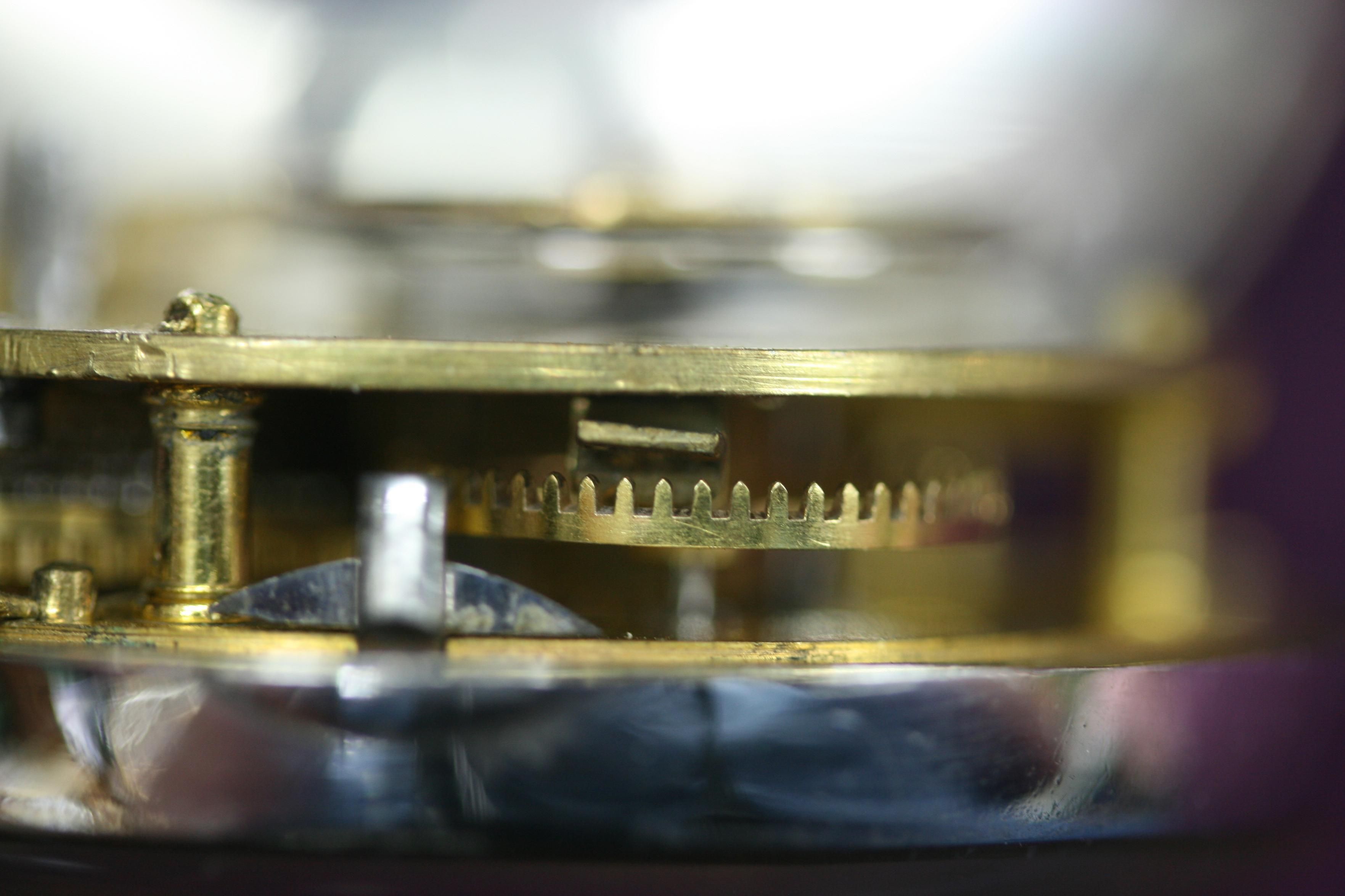 Side view of a pocket watch, with the crown wheel showing, the crown wheel has the teeth facing up, to change the direction of drive