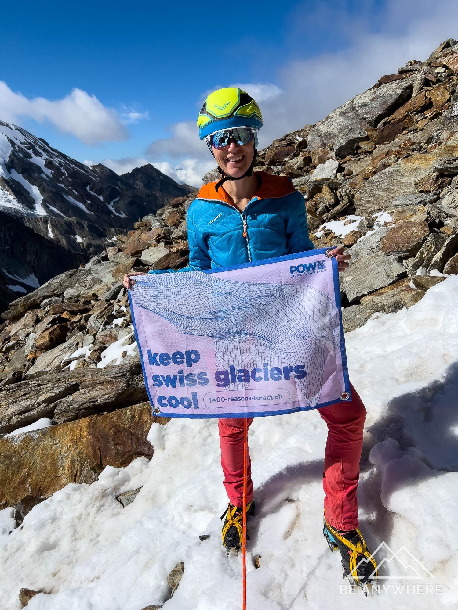 Holding a flagg saying "keep Swiss glaciers cool" on a mountaineering tour on Lagginhorn