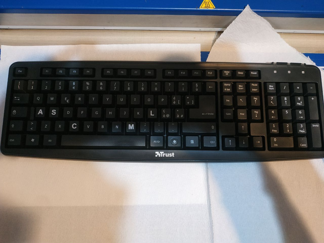 Una tastiera meccanica nera con alcune lettere scritte più grandi del normale.