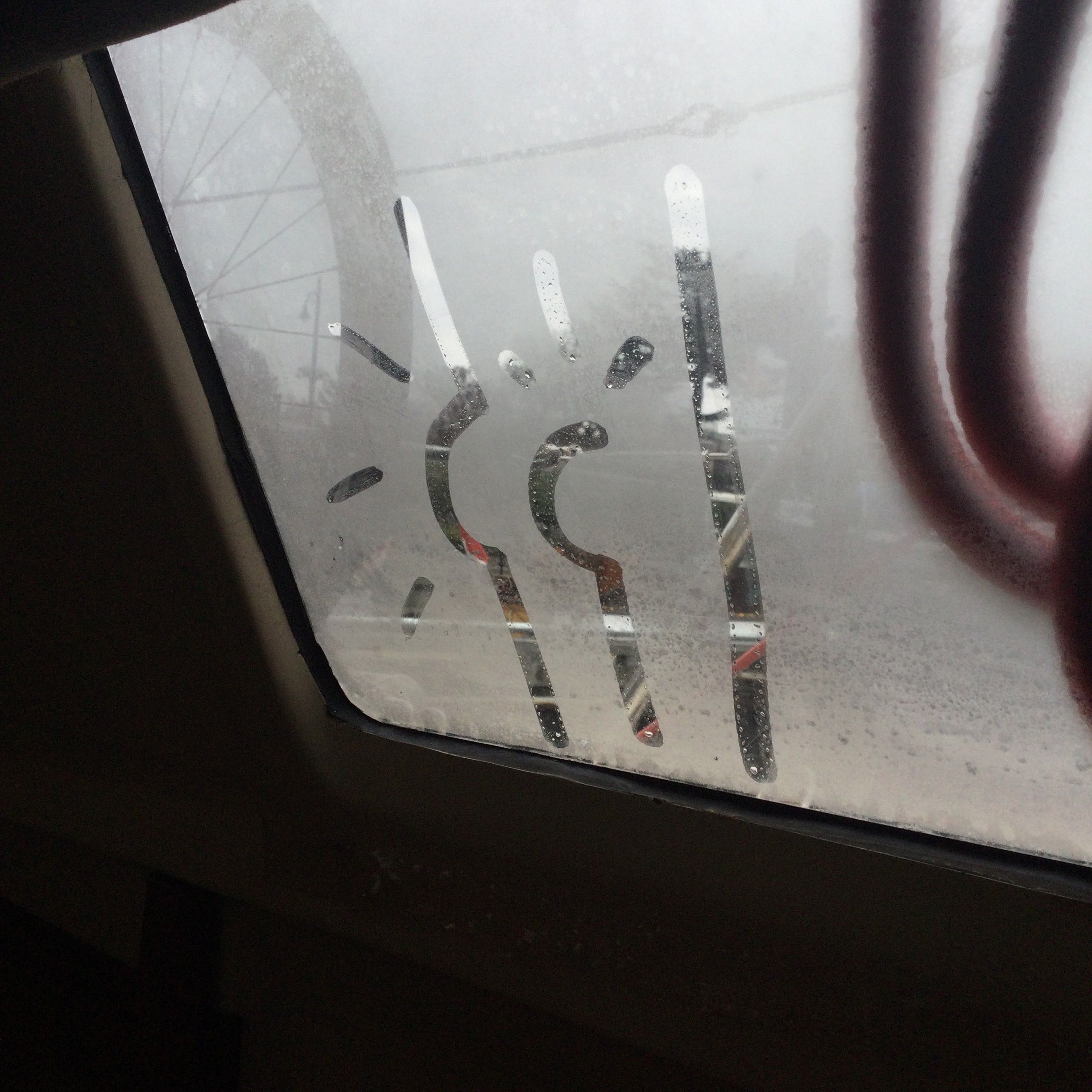 A finger drawing of a human butt on a fogged up sailboat window 