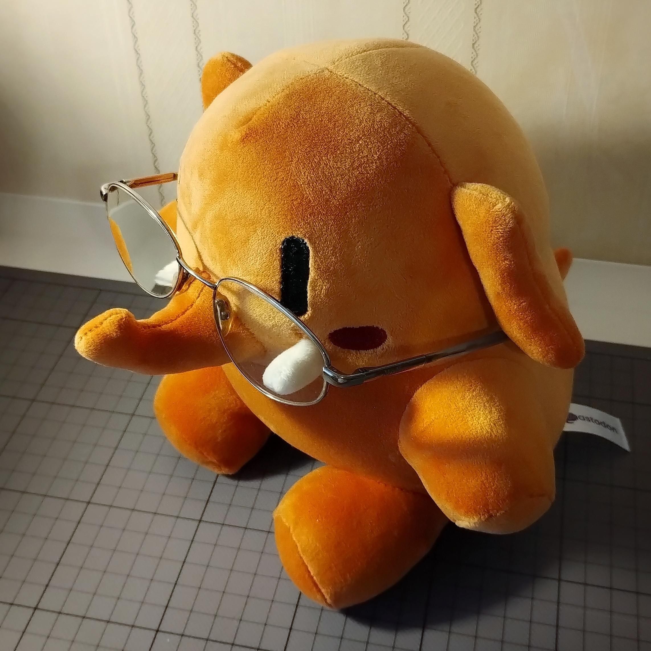 Ein Plüsch-Mastodon-Maskottchen mit Brillen.