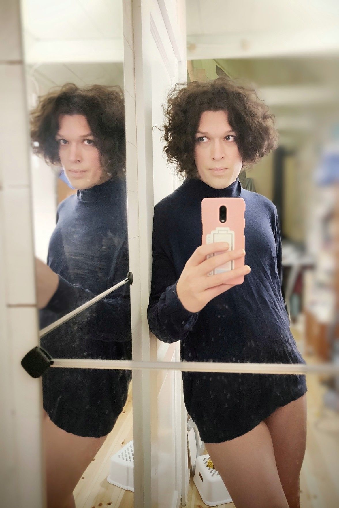 Double mirror selfie. I'm wearing a large dark blue polo shirt and nothing else, glancing into the side mirror, making eye contact if you also look into it.