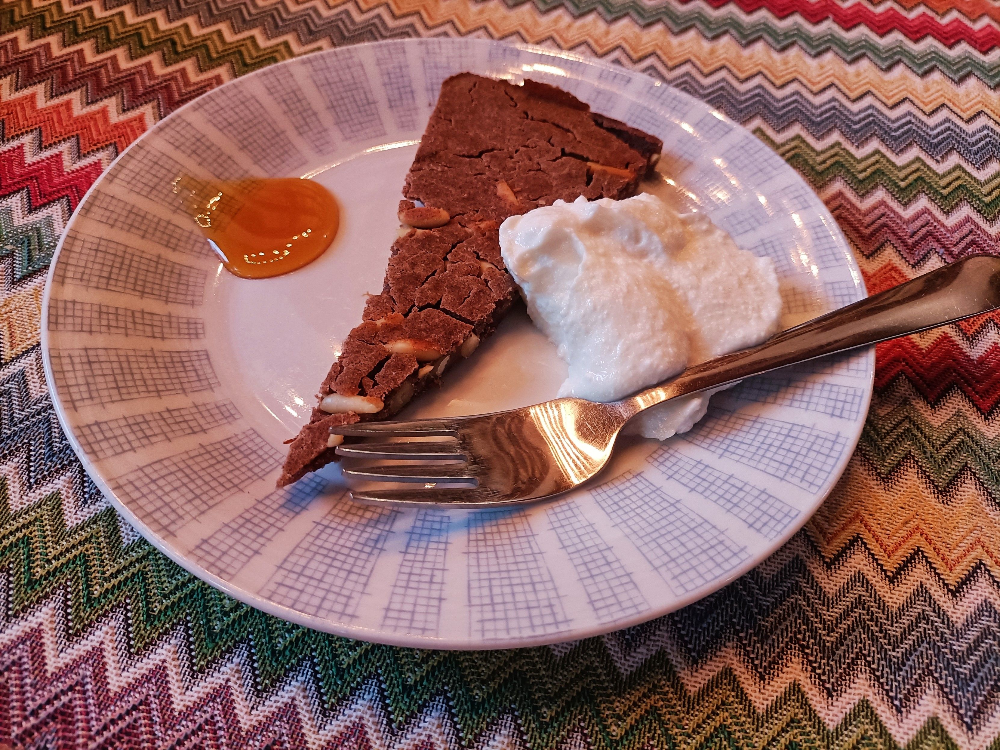 Piattino con forchetta fetta di castagnaccio cucchiaiata di miele e di ricotta 