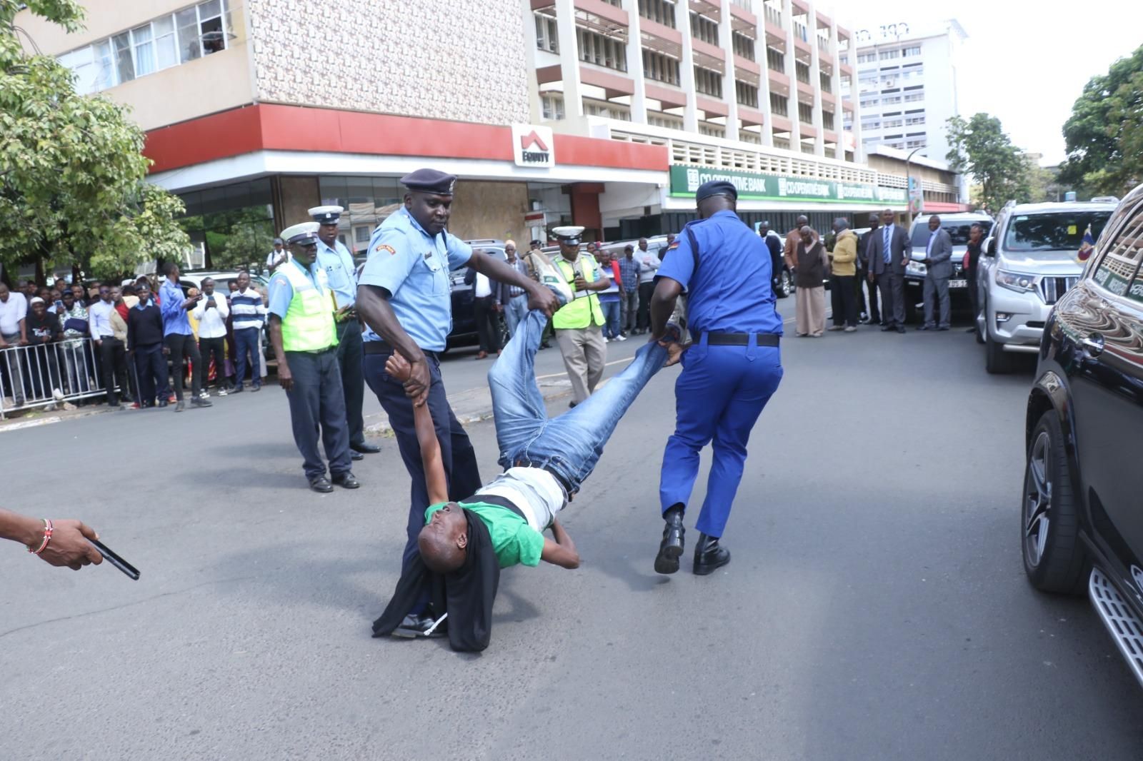 Julius Kamau was dragged by two police officers while others on lookout whilst journalists taking photos after protesting against war in Sudan and Congo. 