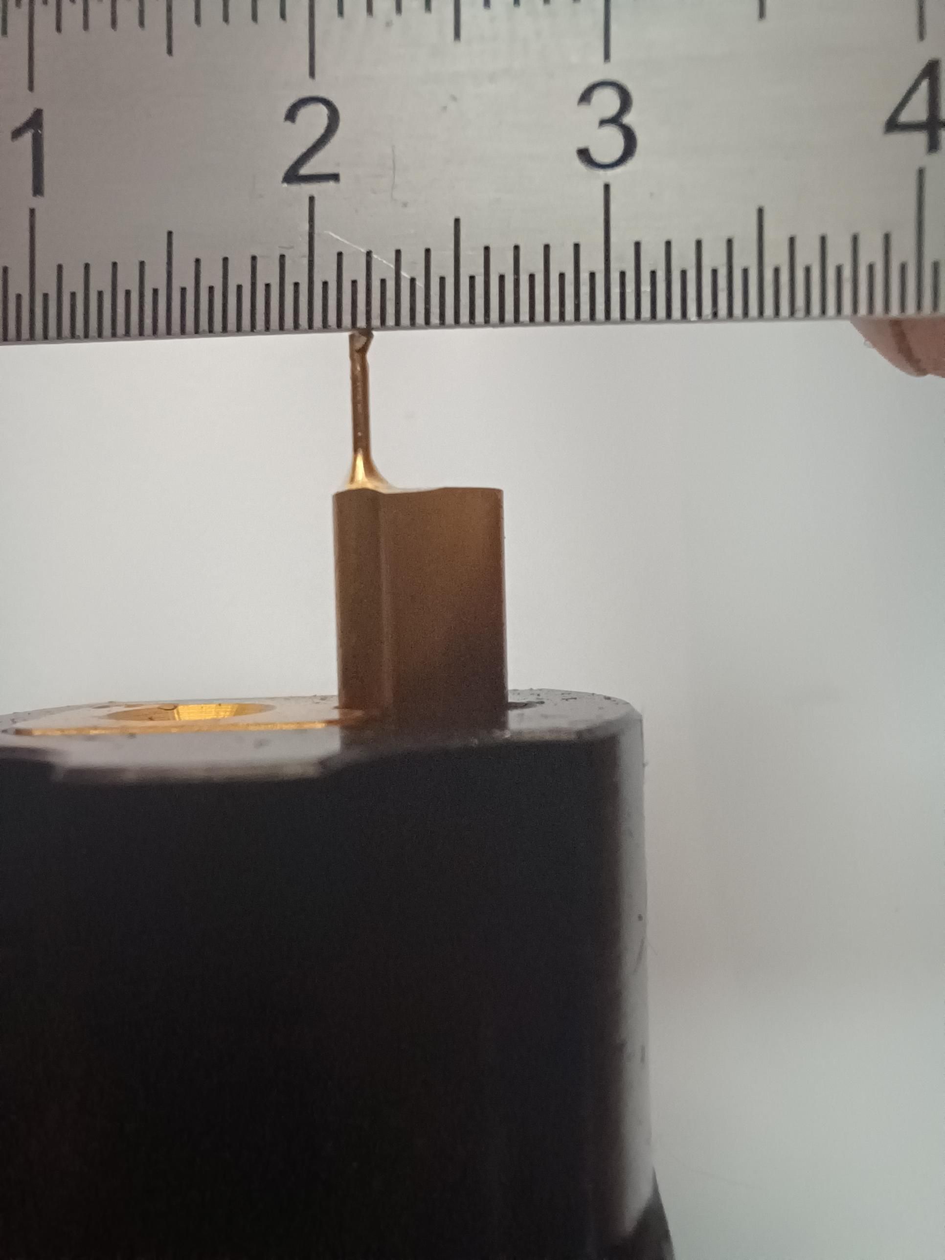 Photo
Alésoir avec revêtement jaune, au dessus duquel se trouve un réglet qui permet de voir que la largeur de l'alésoir est de moins de 1mm.