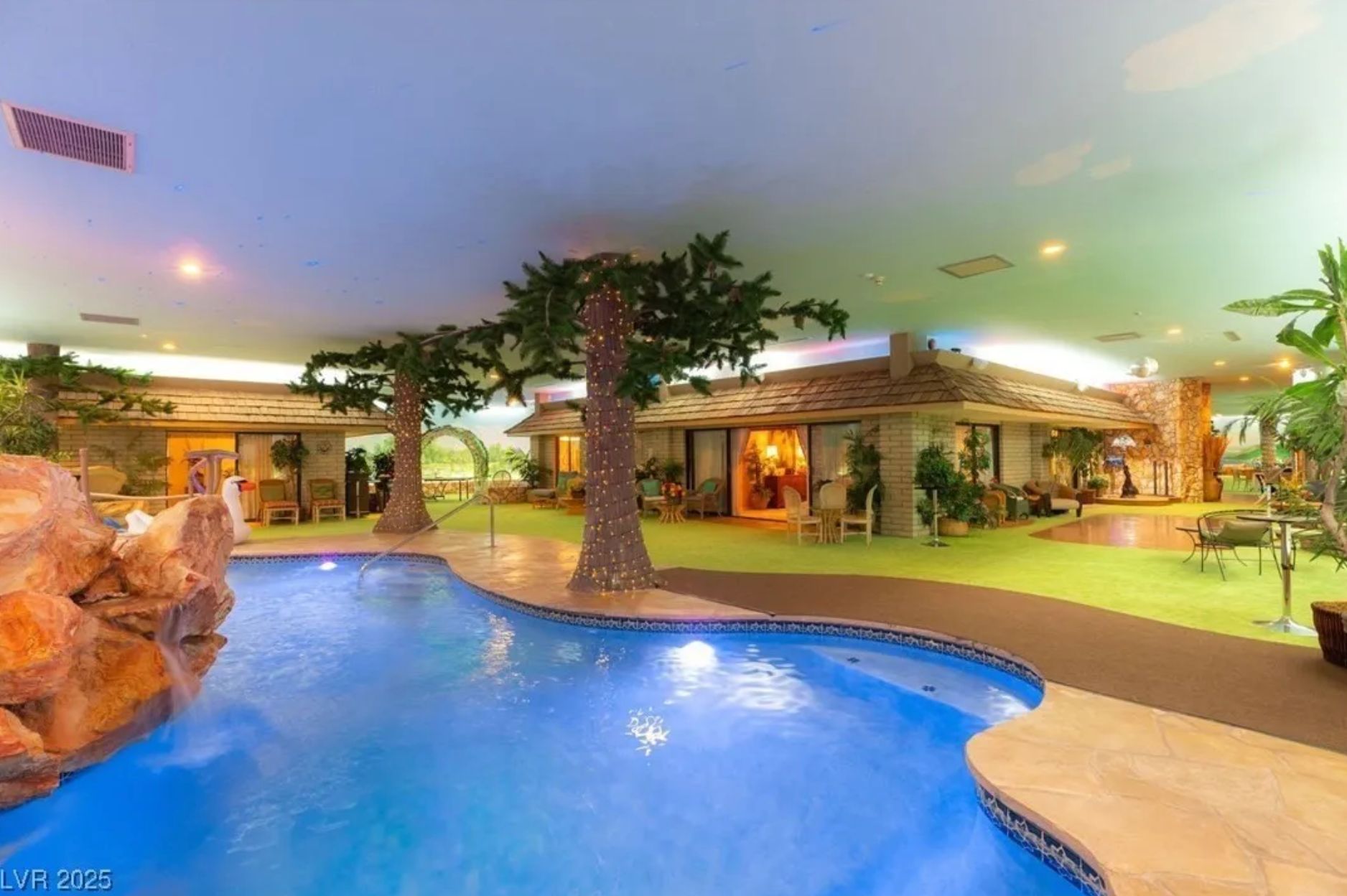 A house with a pool, rocks with waterfall off to the left, and fake green grass surrounding it with fake trees. The unusual thing is that it is entirely underground, and there is a ceiling above all of it, including the roof of the house. 