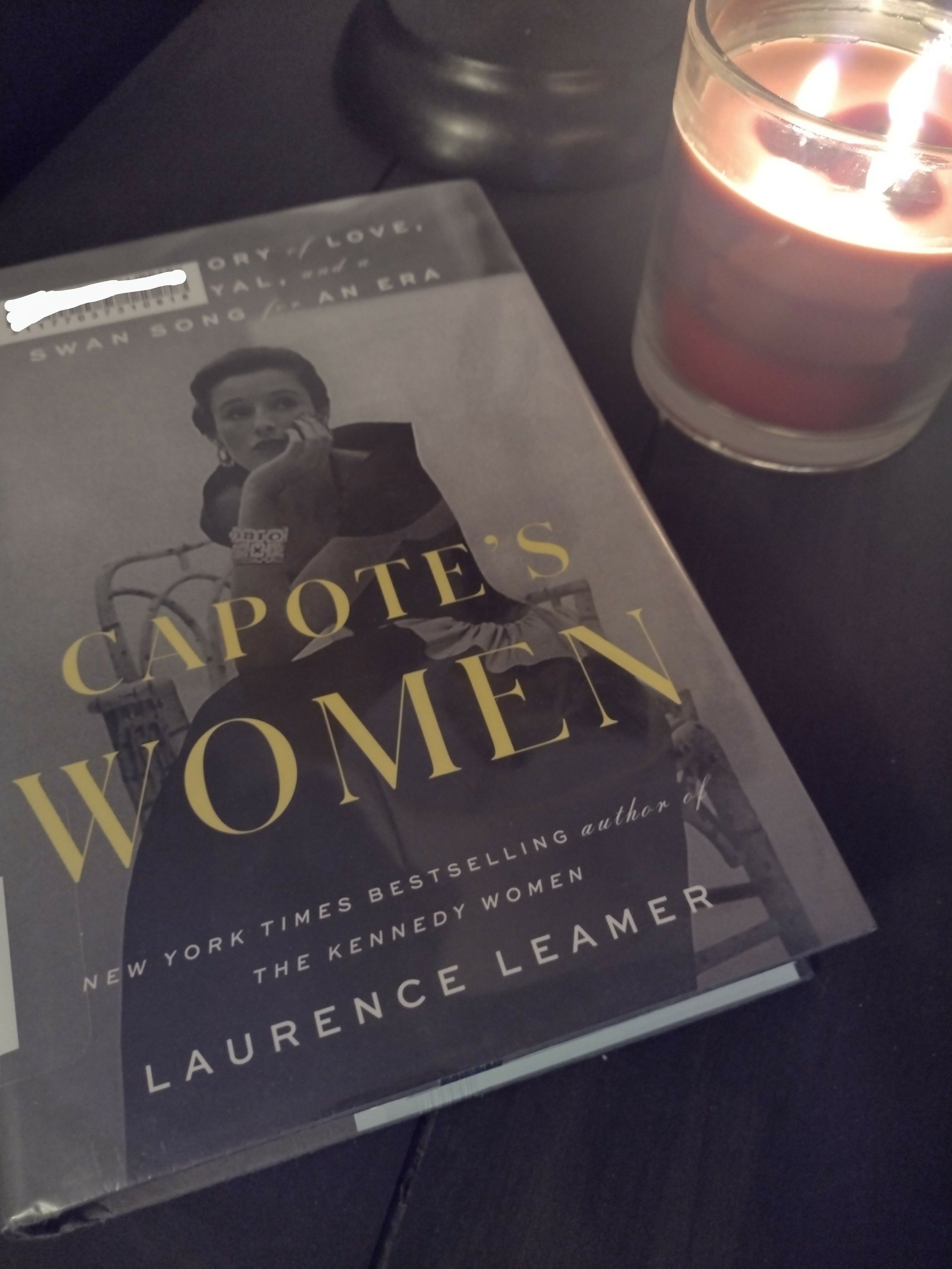 Book on table with a candle near it. 

Lawrence Leamer's Capote's Women with a black and white photo of Babe Paley on the cover. 