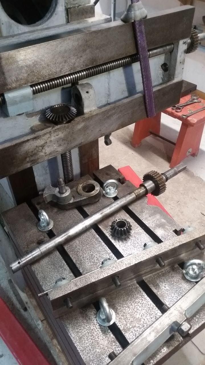 Alla limatrice ho smontato la tavola e l'alberino del movimento dell'asse Z (verticale).
I pezzi sono appoggiati sulla tavola.
I golfari infilati nelle cave a T servono per alzare la tavola con la capra.
Ora proverò a smontare l'ingranaggio in cima all'alberino per verificare una mia teoria.
