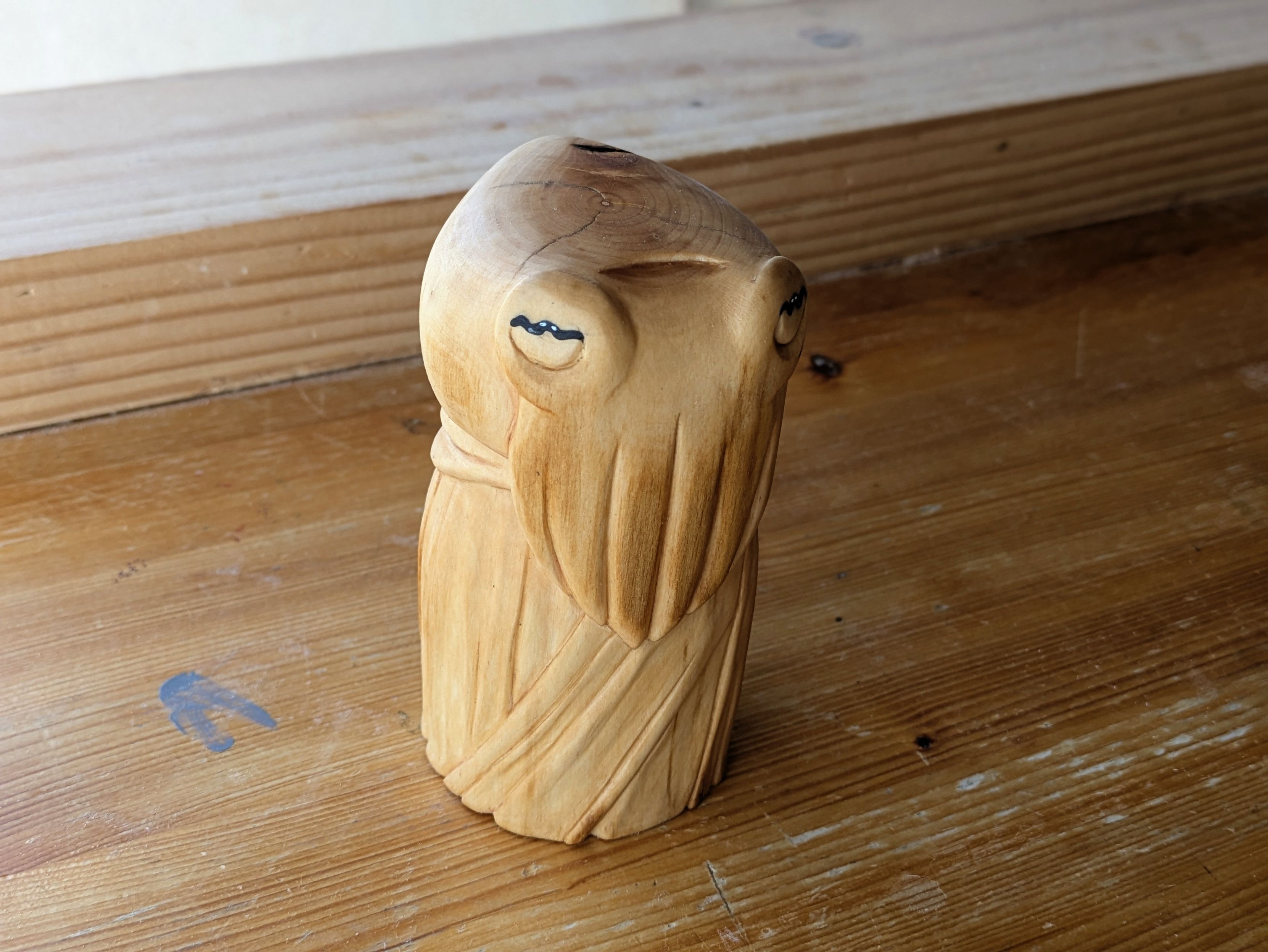 Woodcarved humanoid cuttlefish on a workbench wearing a robe