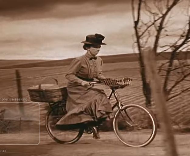 Woman in a dress on an old fashioned bicycle