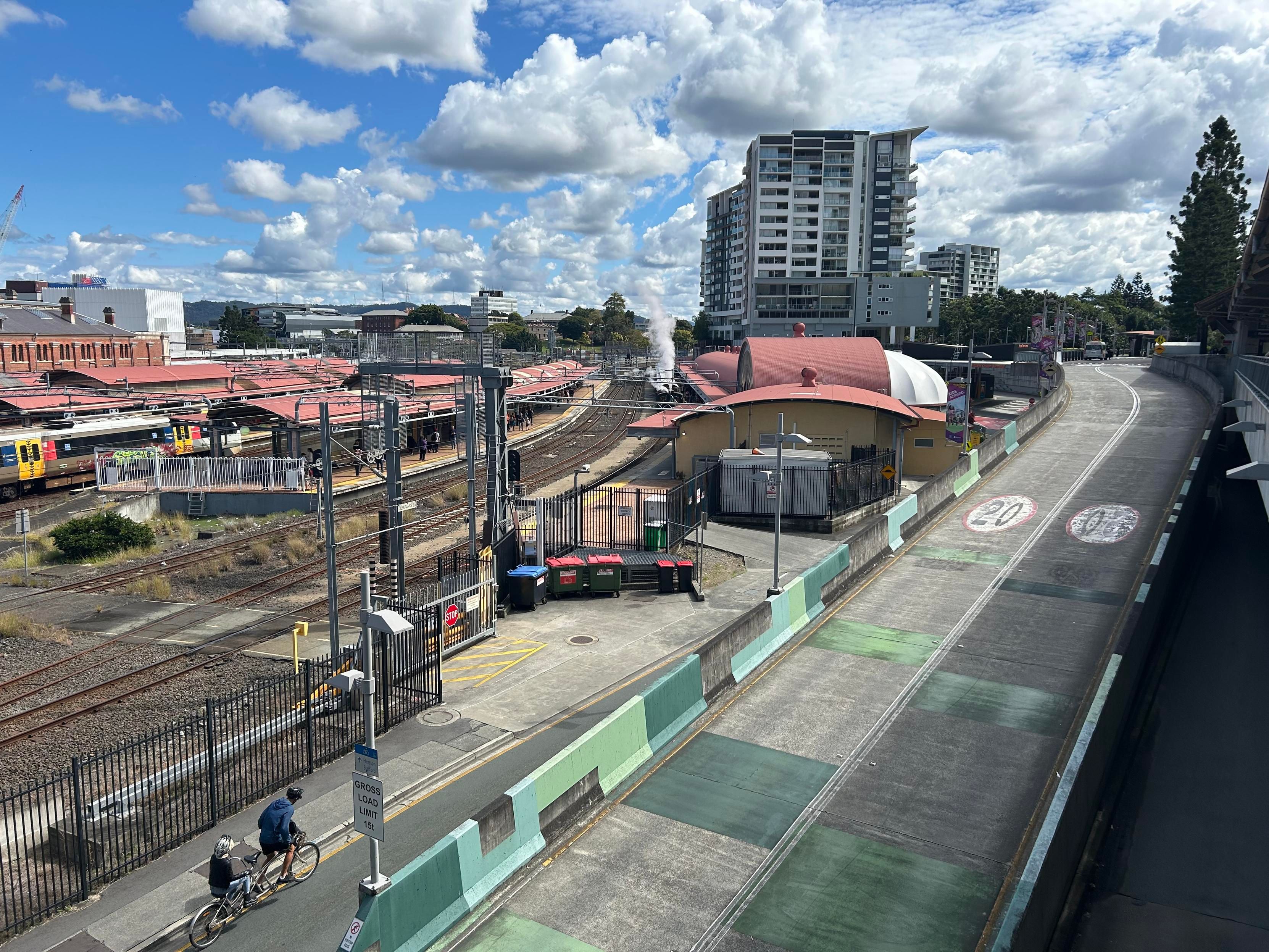 The same steam train is seen standing at platform ten of Roma Street station, views from a nearby overhead walkway.