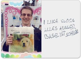 picture of some guy holding some ique nintendogs thing, to the right is handwritten text that reads "I LIKE DOGS" followed by "ALLES AUSSER BASEL IST SCHEISSE", which is german for "everywhere except basel is shit"