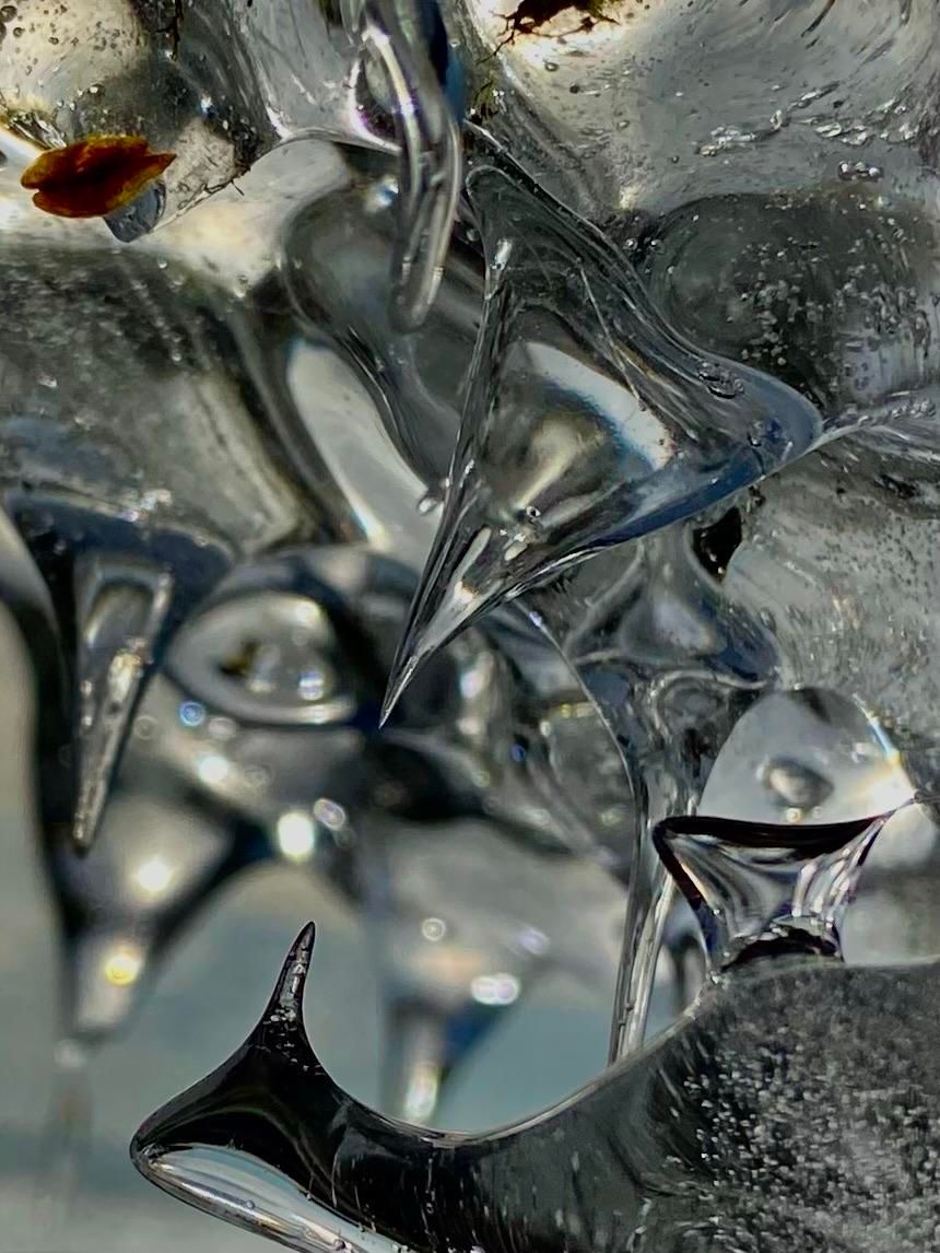 Closeup of a strange ice formation that is mostly round and curving, but with sharp points going both up and down into an empty space in the middle, almost like an ice monster's jaw. 