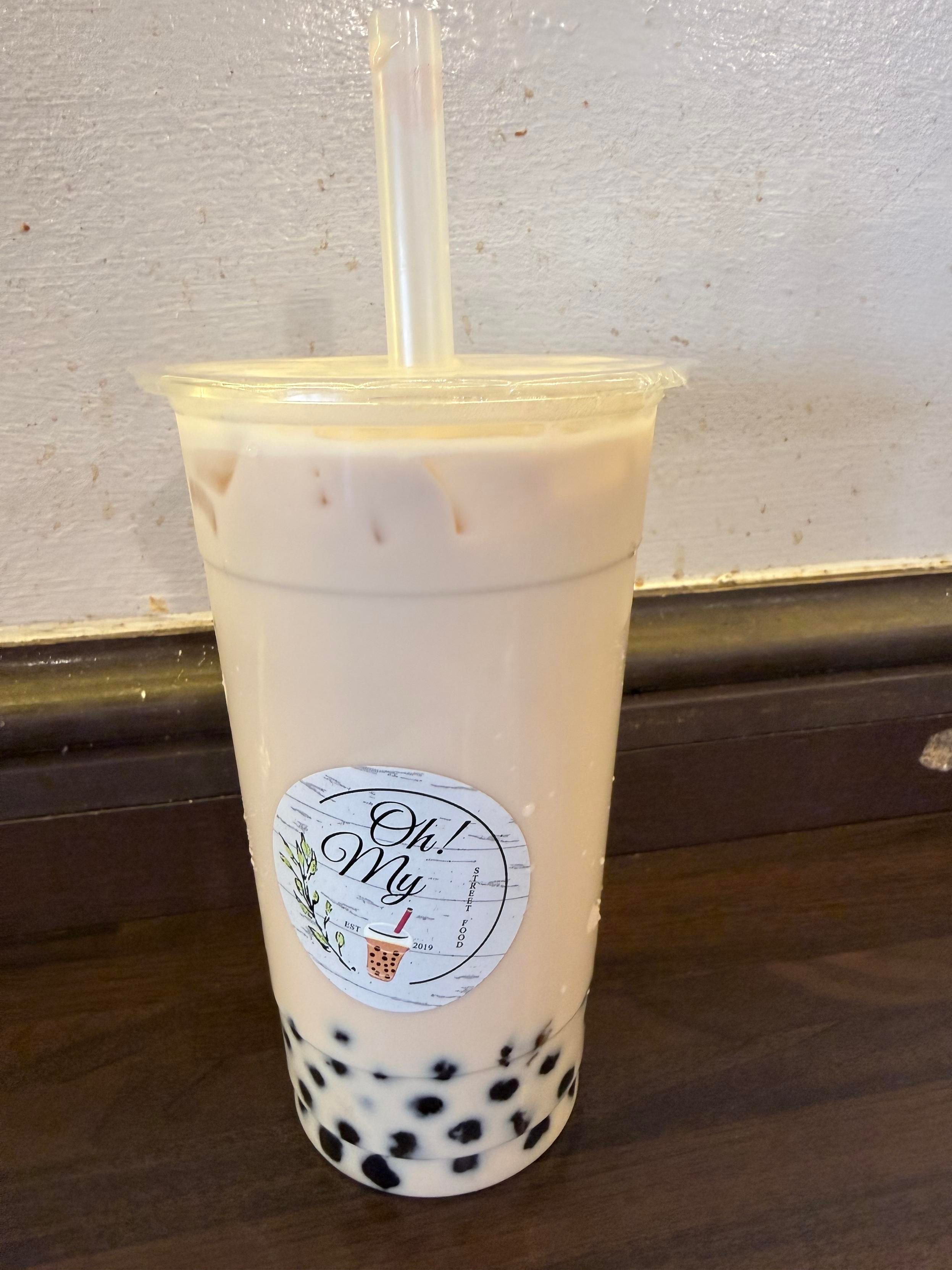 Picture of a cup of boba milk tea with a sticker saying “Oh My!”. The restaurant is called Oh My Street Food!
