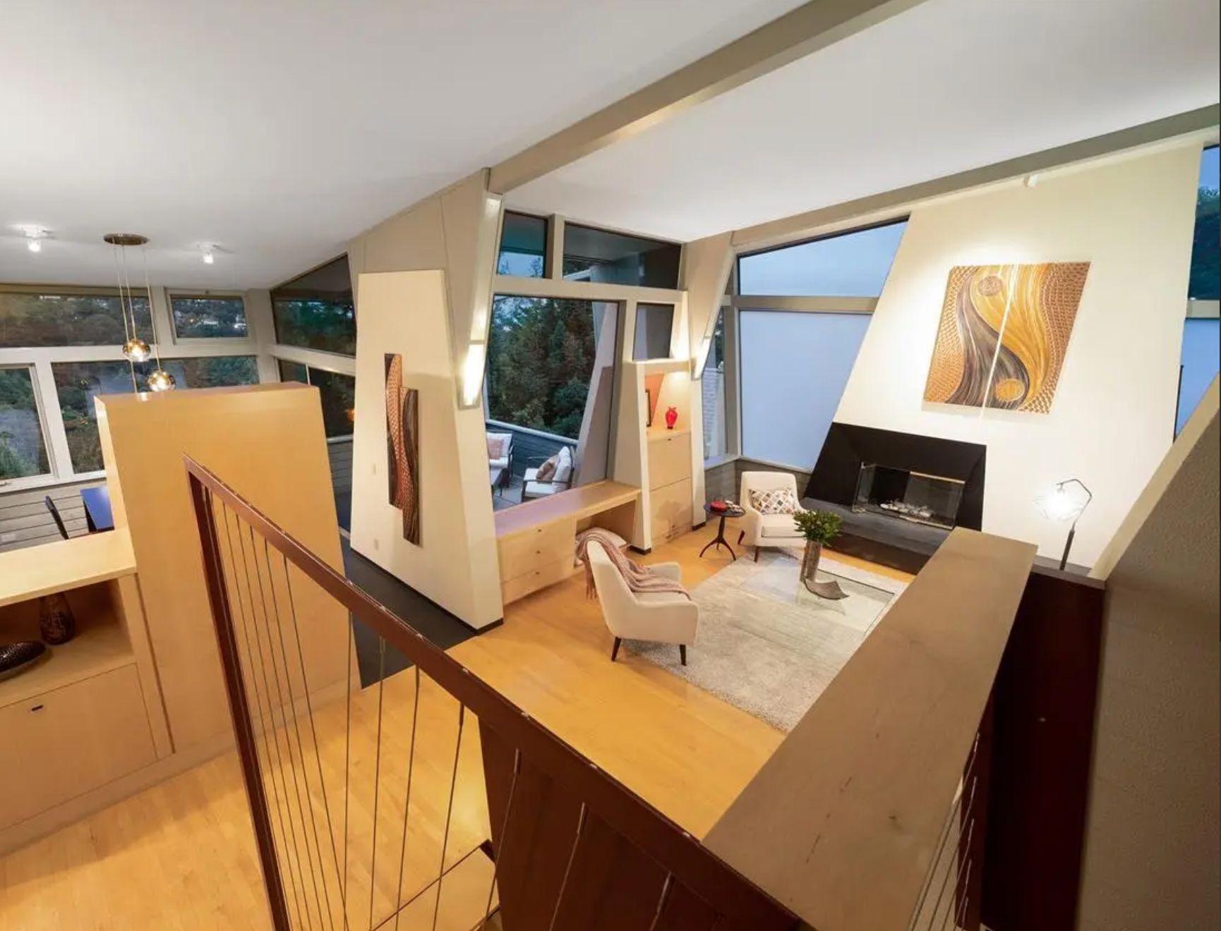 A living room, as seen from upstairs looking down. The walls are on a slant, as are the windows